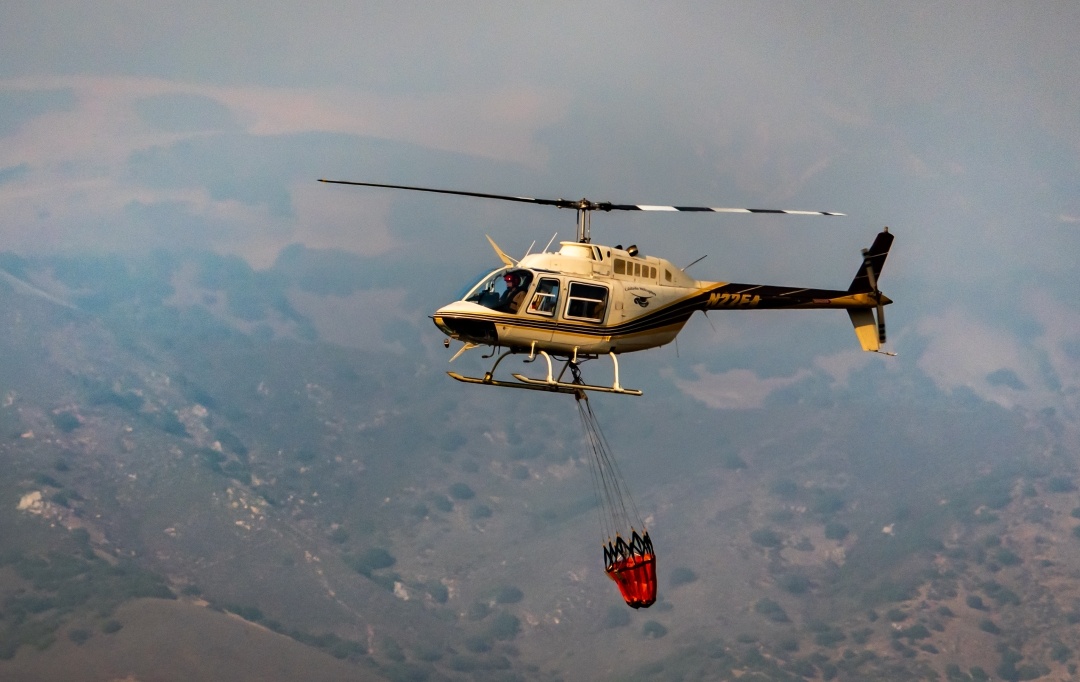 helicopter carrying bucket of water