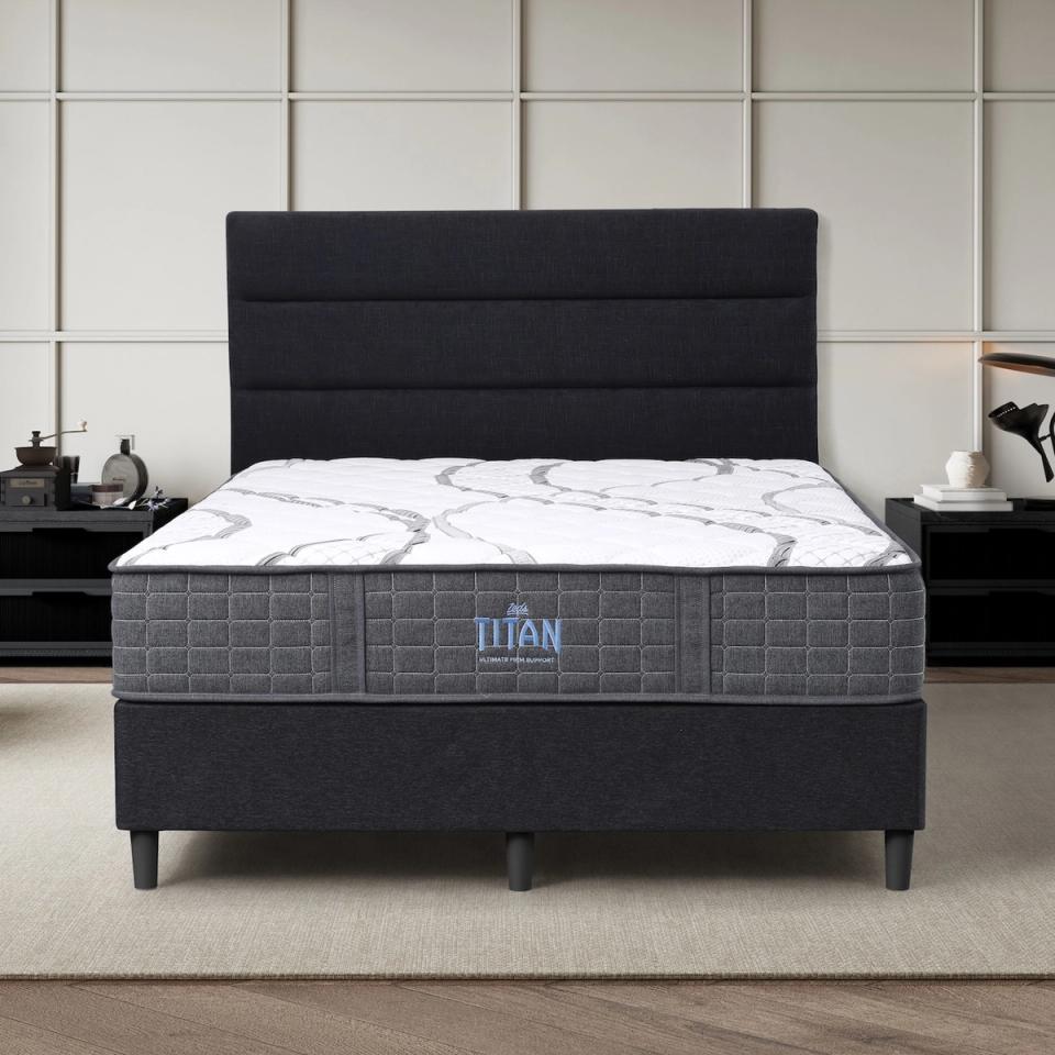 Dreamland Titan mattress, queen size, shown front-on in a styled bedroom.