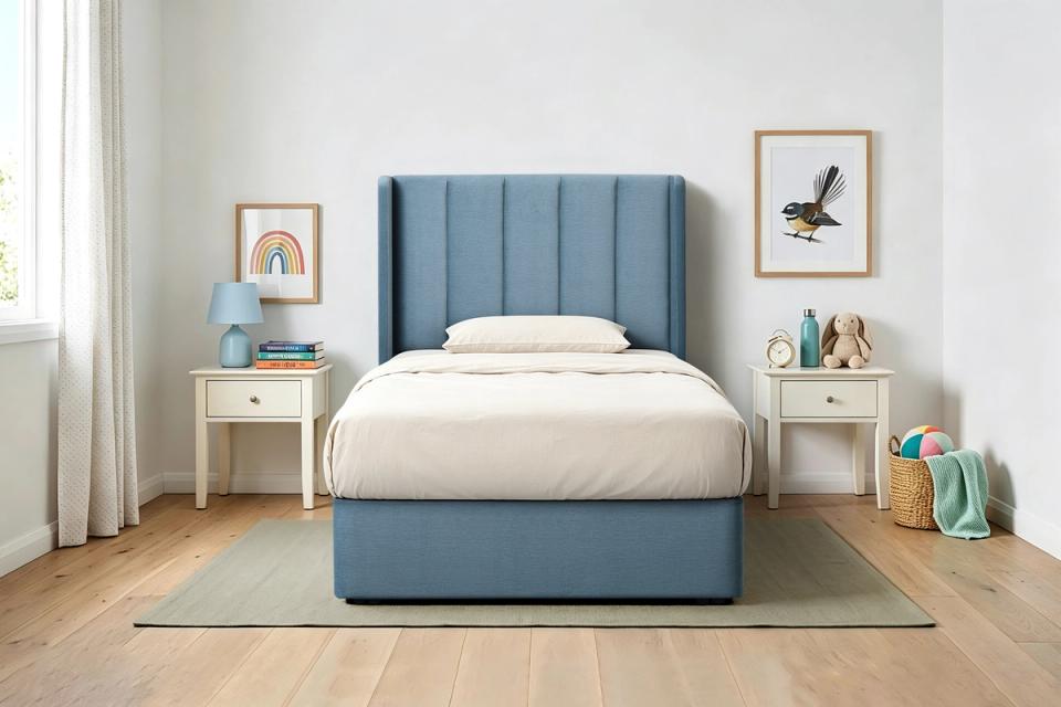 Theo upholstered king single bed frame in blue, made up in a child’s bedroom
