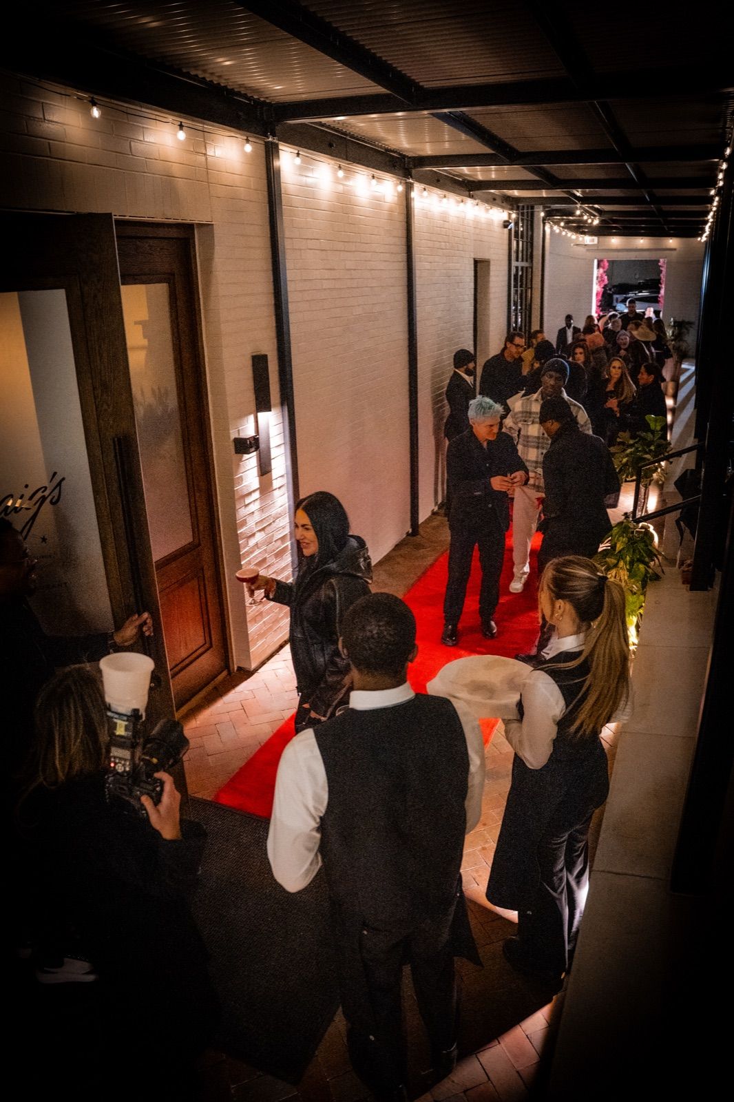 Overhead view of the string-lit covered corridor with guests arriving along the red carpet