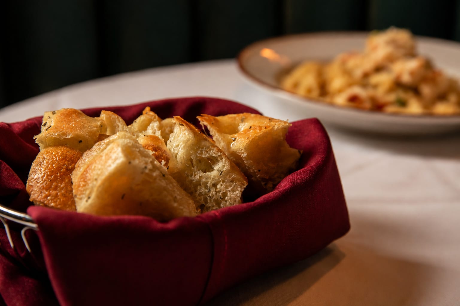 Freshly baked bread in a burgundy napkin-lined basket