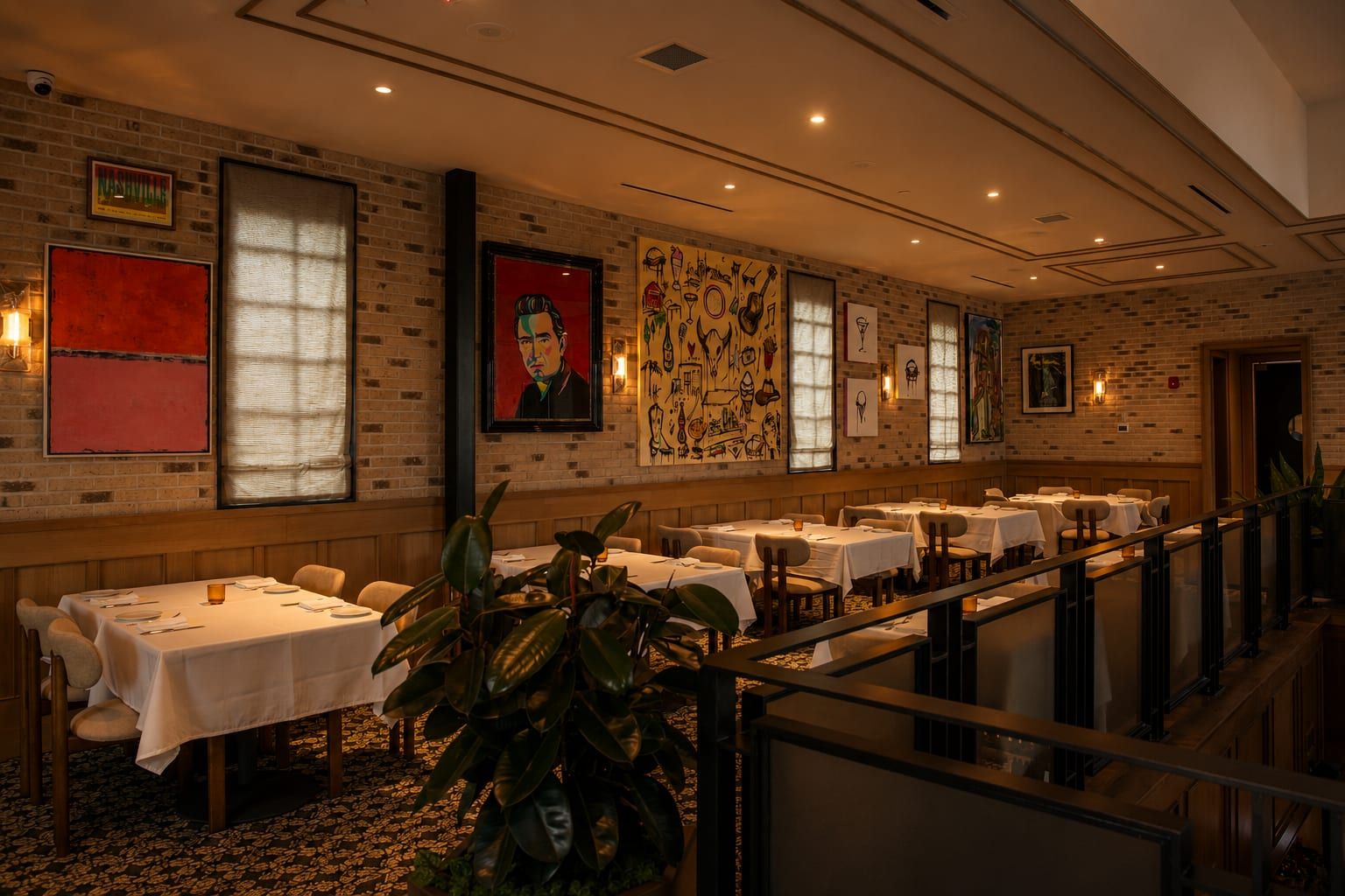 White-brick dining room with set tables beneath pop-art portraits and a sketch mural