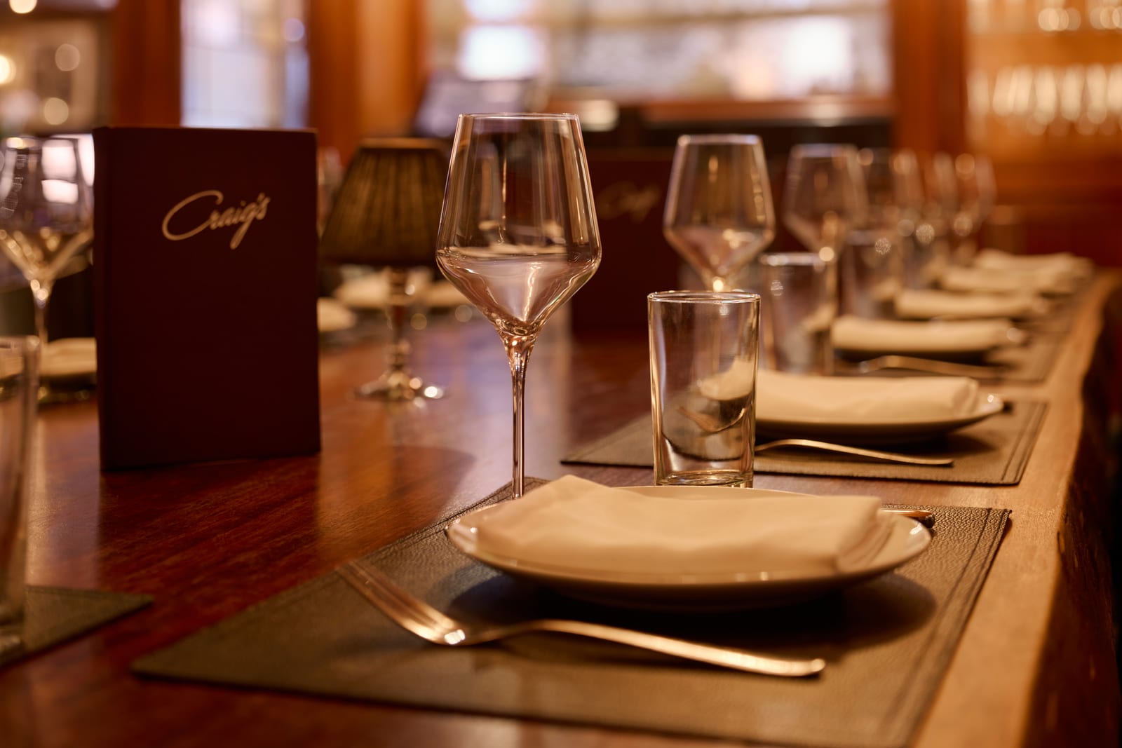 Wine glasses and a folded napkin at a candlelit place setting