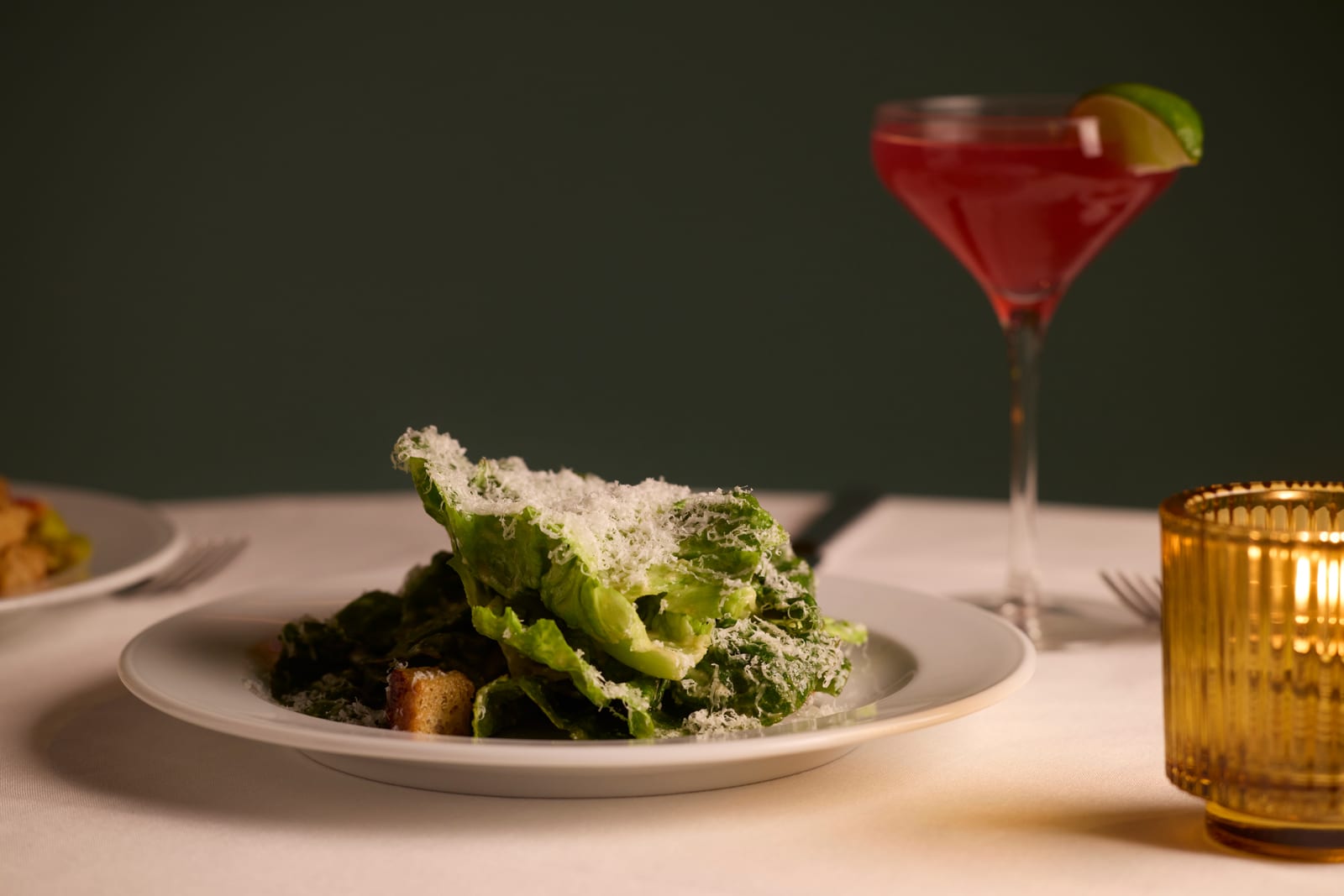 Craig's Caesar salad plate beside a chilled pink cocktail