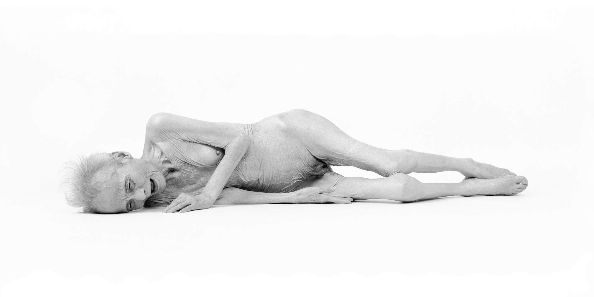 Manabu Yamanaka, Gyahtei #1, 1995. Silver gelatin print: a slender nude figure lying on its side against a white background.