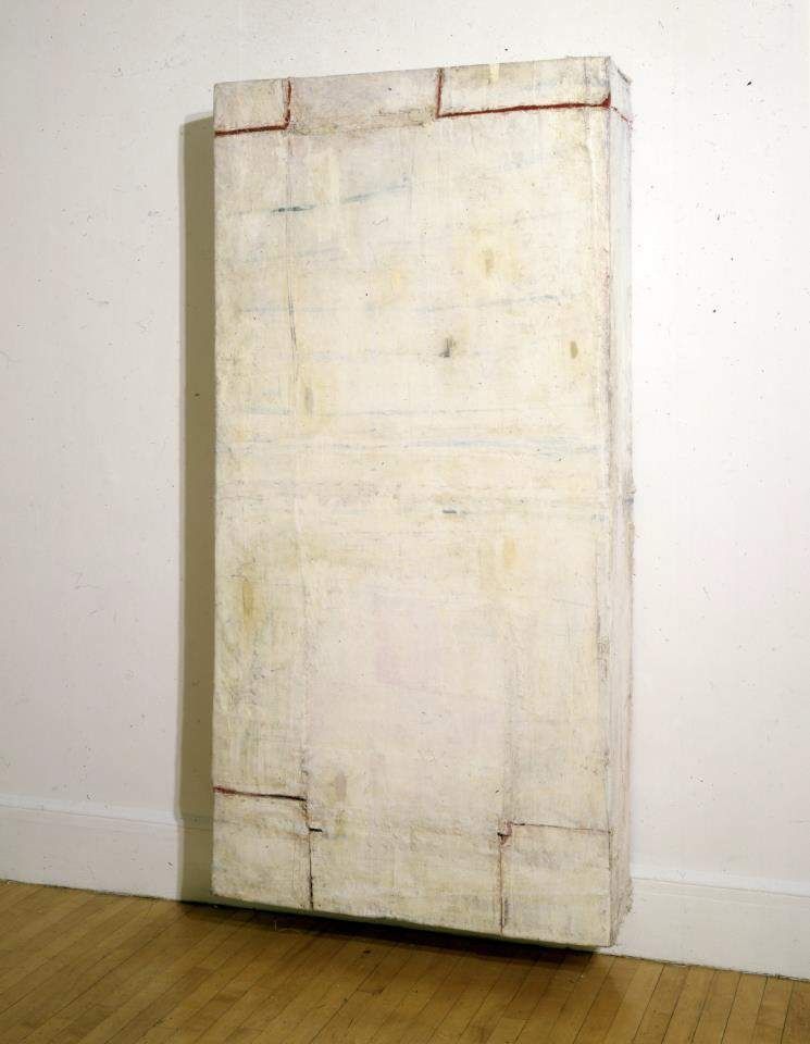 Lawrence Carroll, Untitled, 1987. Mixed media: a tall, pale, box-like painted form standing against a gallery wall.