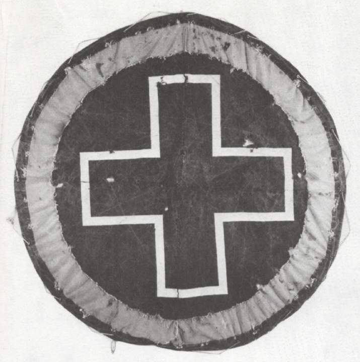 Holt Quentel, Cross Disc, 1987. Latex, canvas and rope: a large circular disc with a white cross on a dark ground.