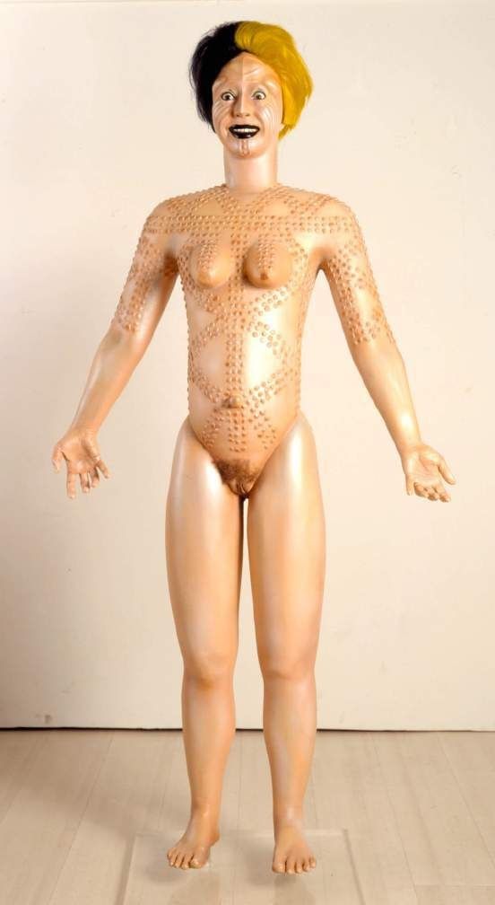 ORLAN, Nuna Sculpture with Scars from Burkina and Body of Euro-Saint-Étienne, 2000. Resin sculpture of a standing female figure with a wig, on a transparent plinth.