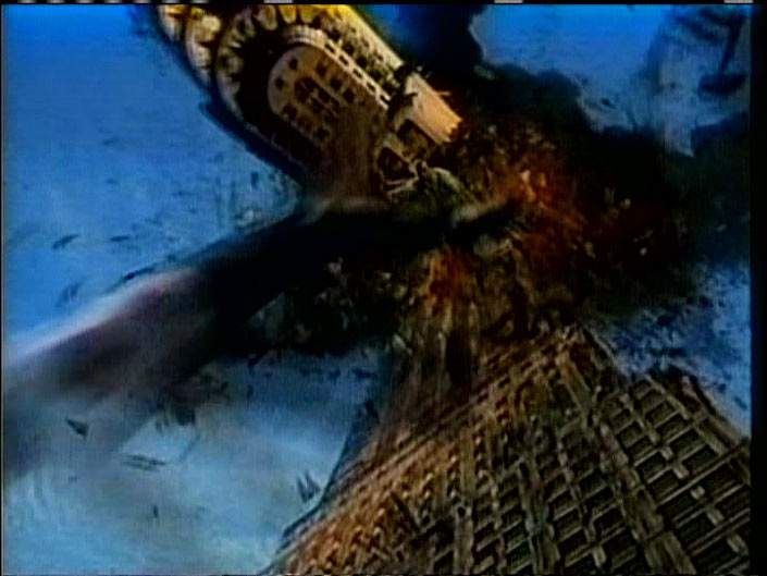 Tracey Moffatt, Doomed, 2007. Video still: dark smoke over a scene of destruction against a blue sky.
