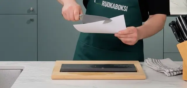 Kokki teroittamassa veistä keittiössä