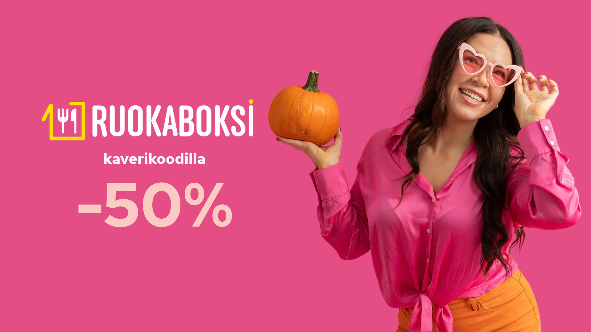 Nainen pinkillä taustalla pitelee kurpitsaa.