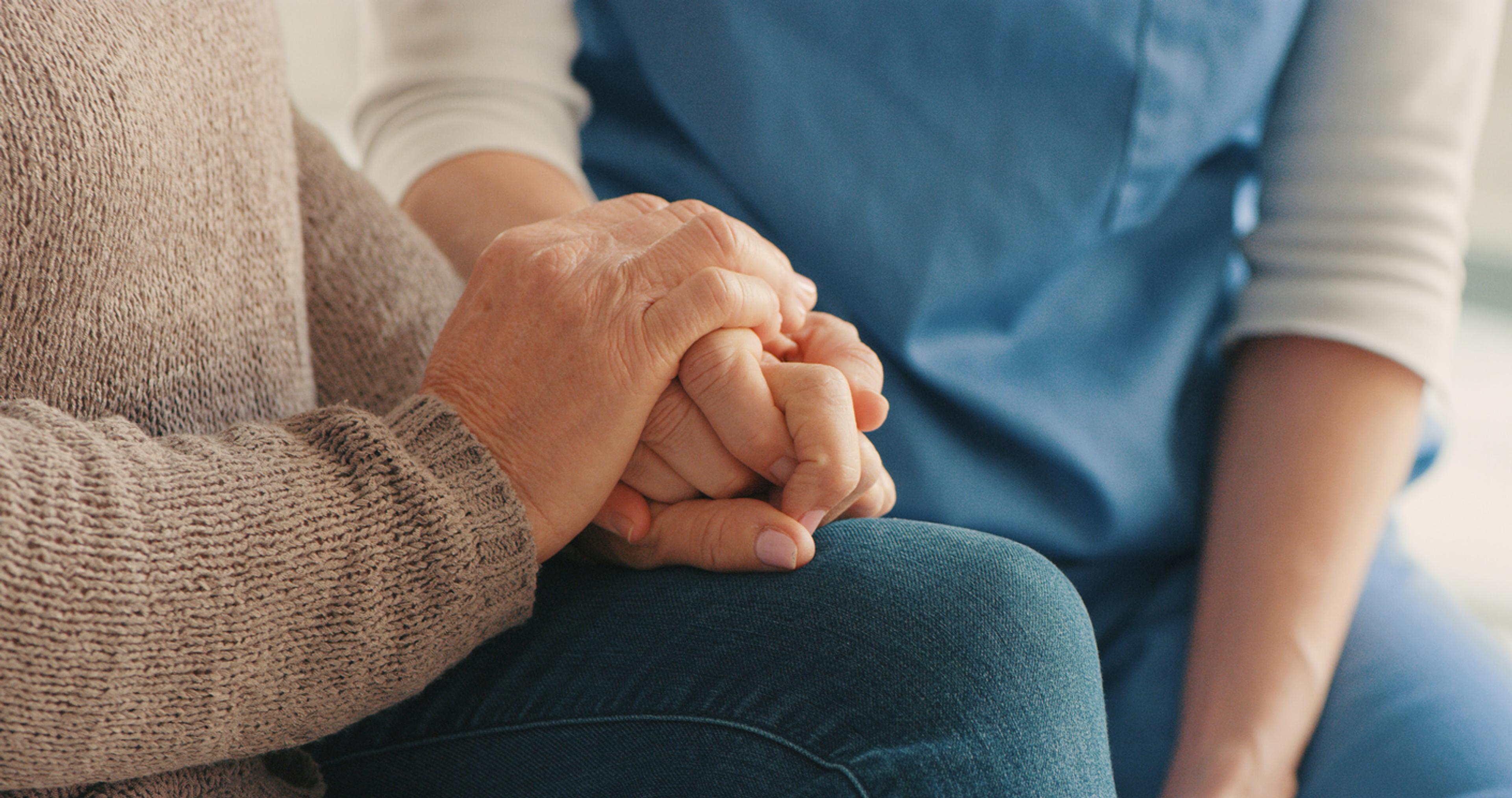 a close up photo of a man and a woman holding hands, comforting each other.