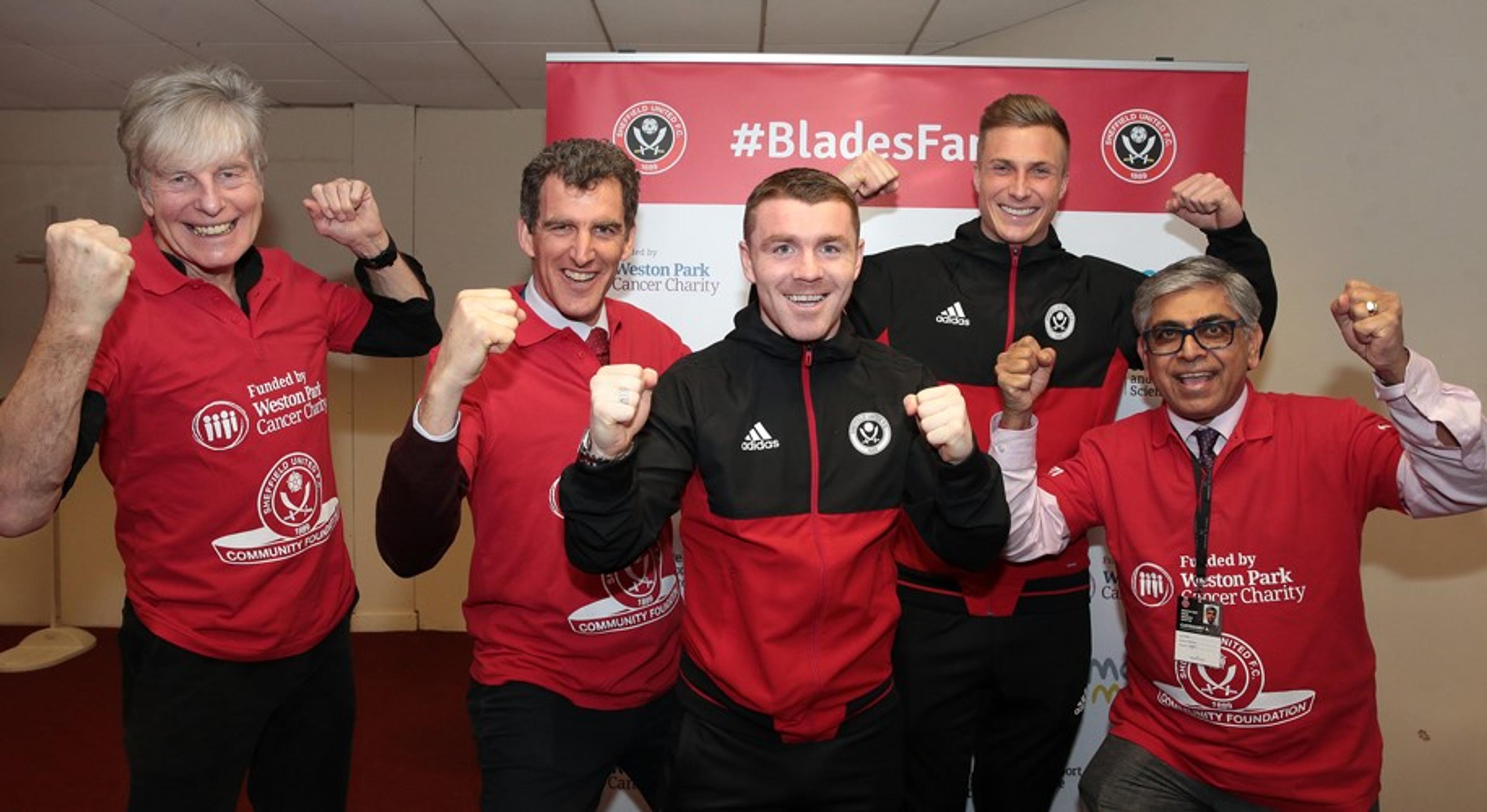 Five men cheering wearing red, black and red Sheffield United football clothing