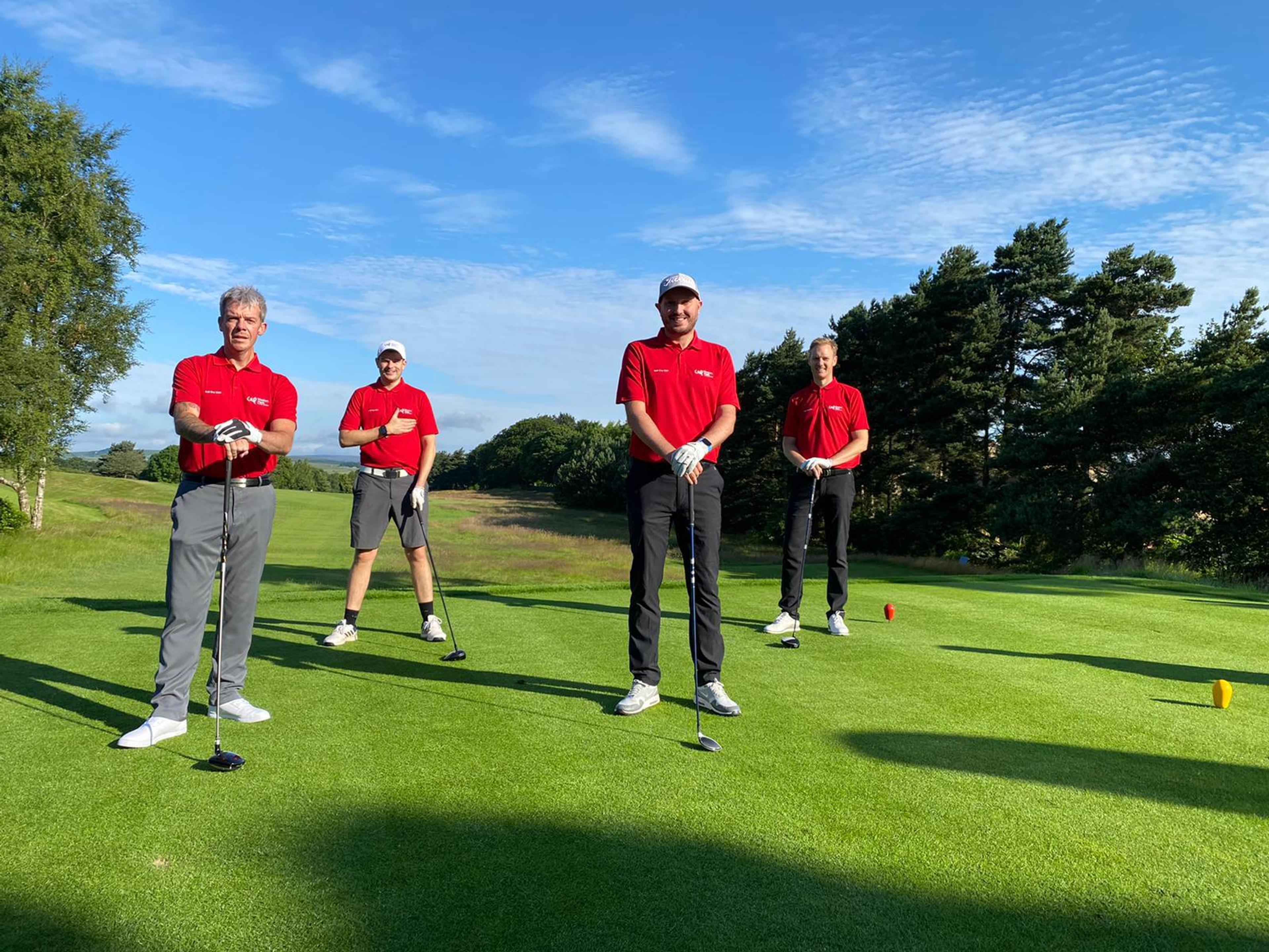 A group of four male golfers stood socially distanced holding golf clubs at Hallamshire golf course