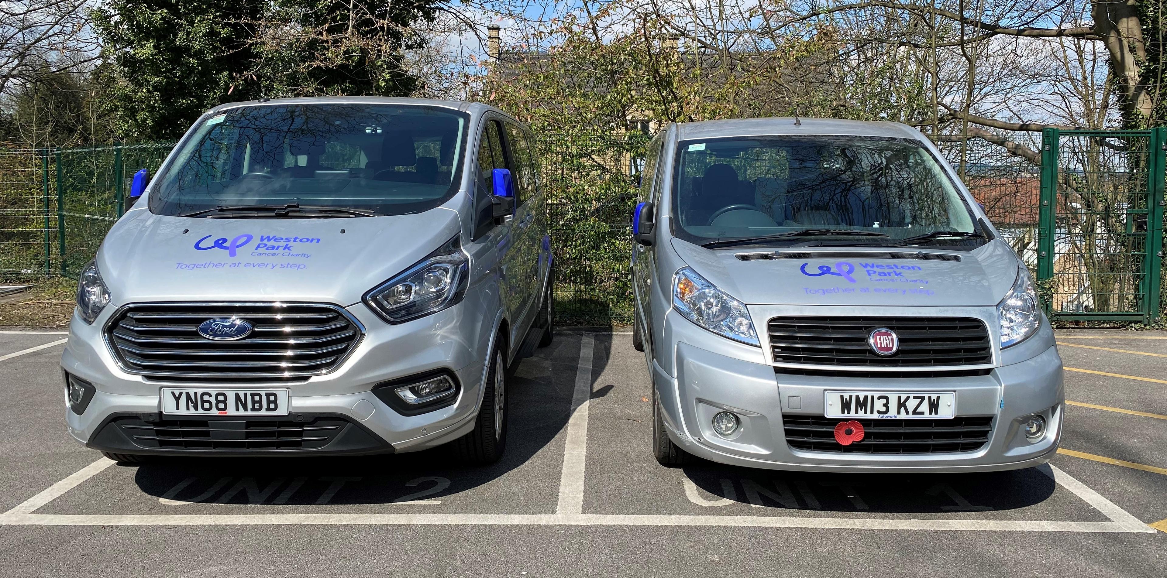 Two silver parked vehicles which have the Weston Park Cancer Charity logo on them
