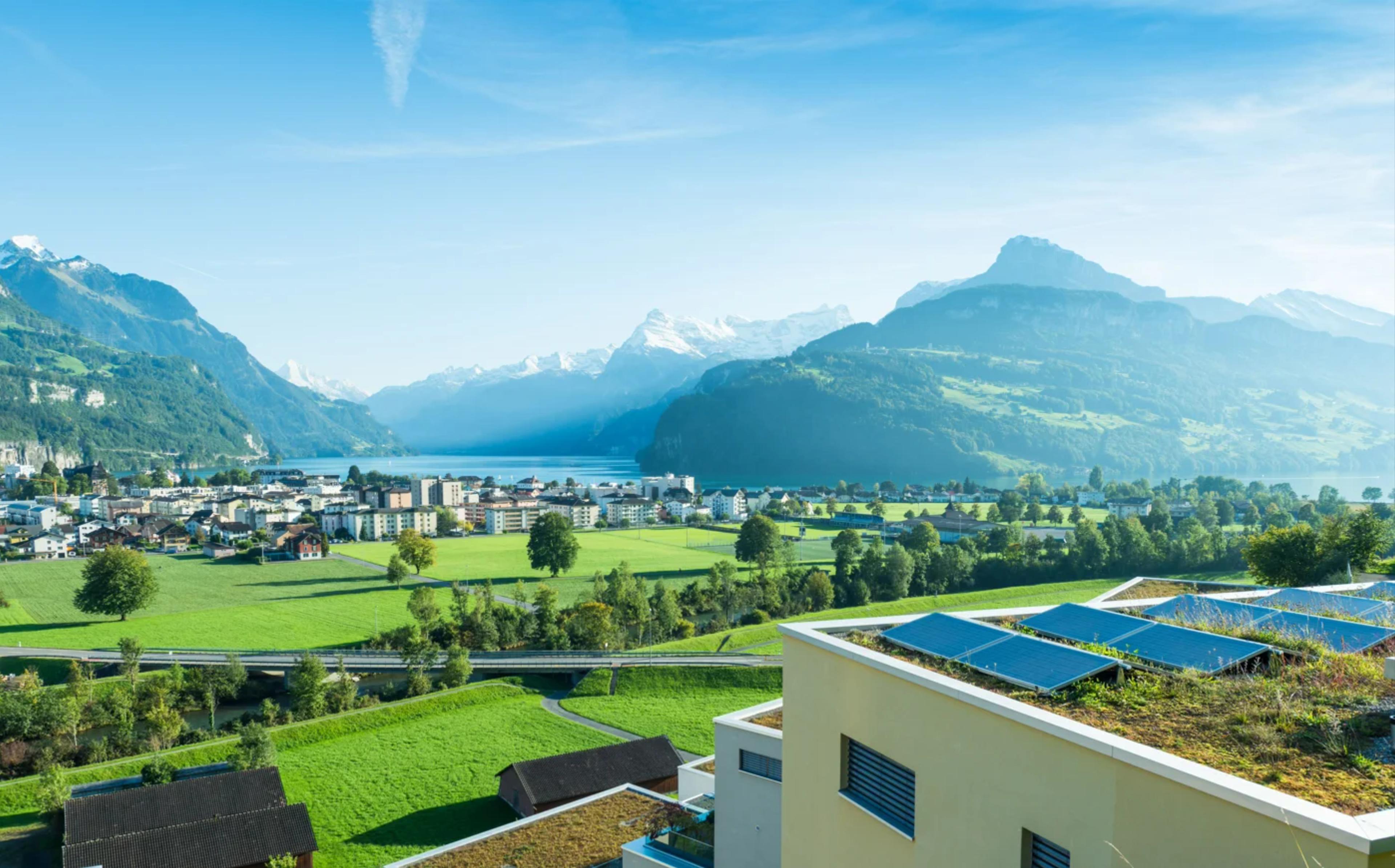 Gebäude mit Photovoltaikanlage mit schweizer Landschaft im Hintergrund 