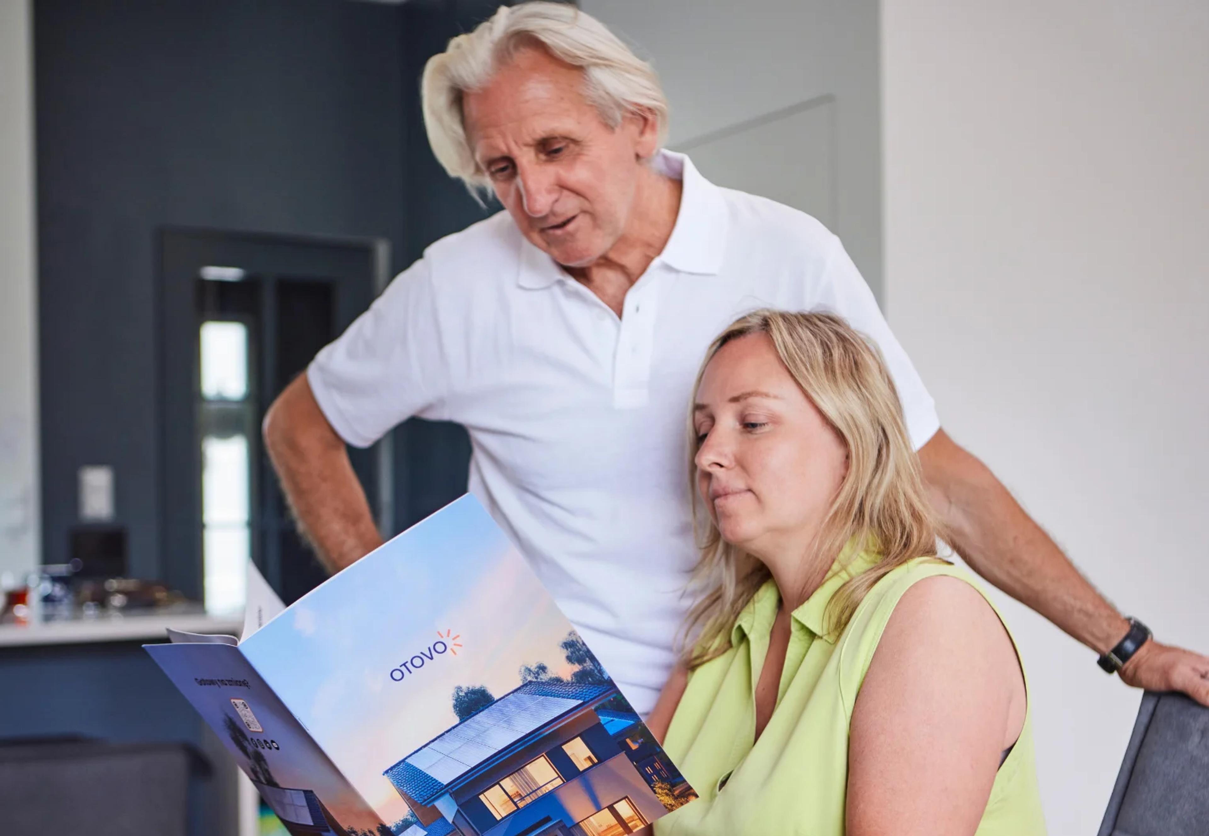 Mann und Frau schauen sich eine Otovo Brochüre an