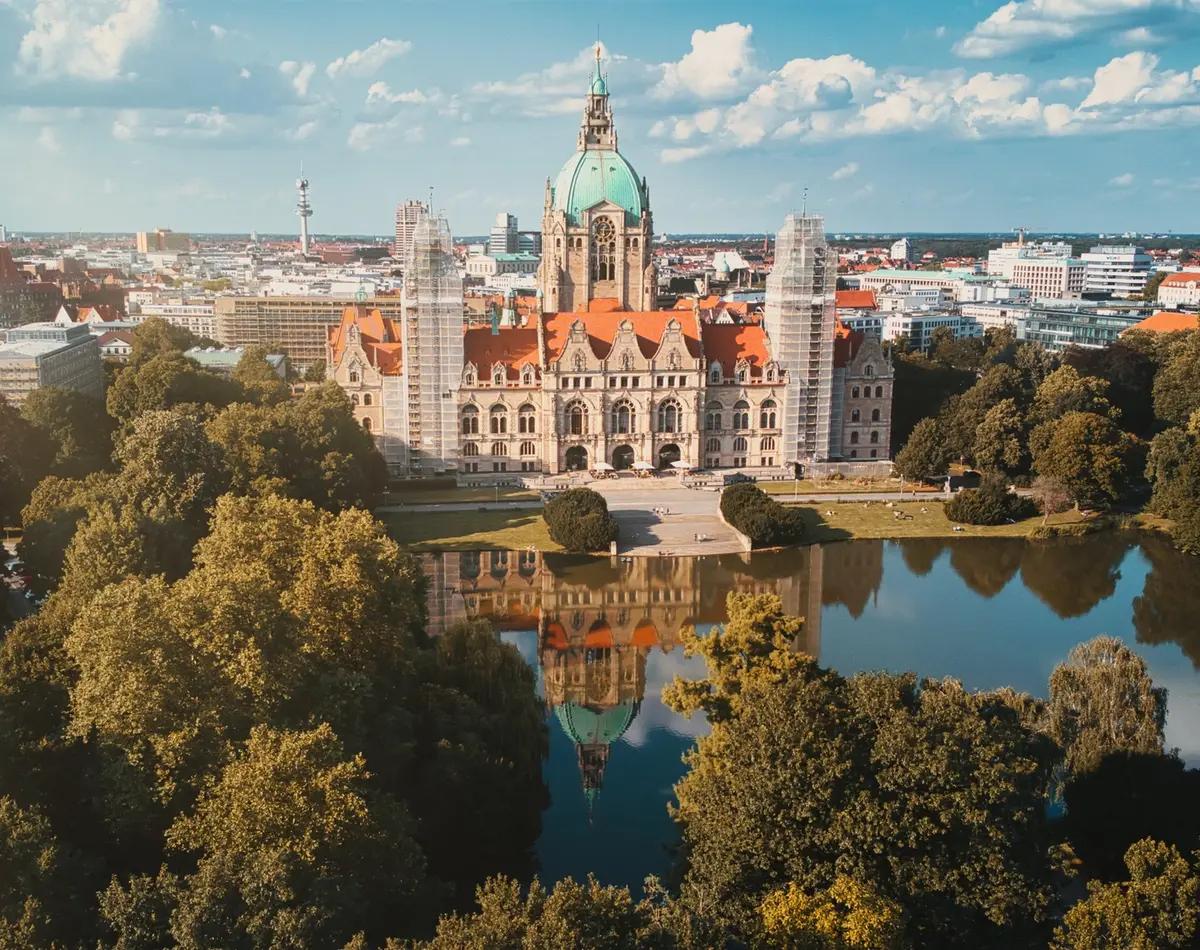 Ein Schloss und ein Park in Hannover in Niedersachsen im Sonnenschein.