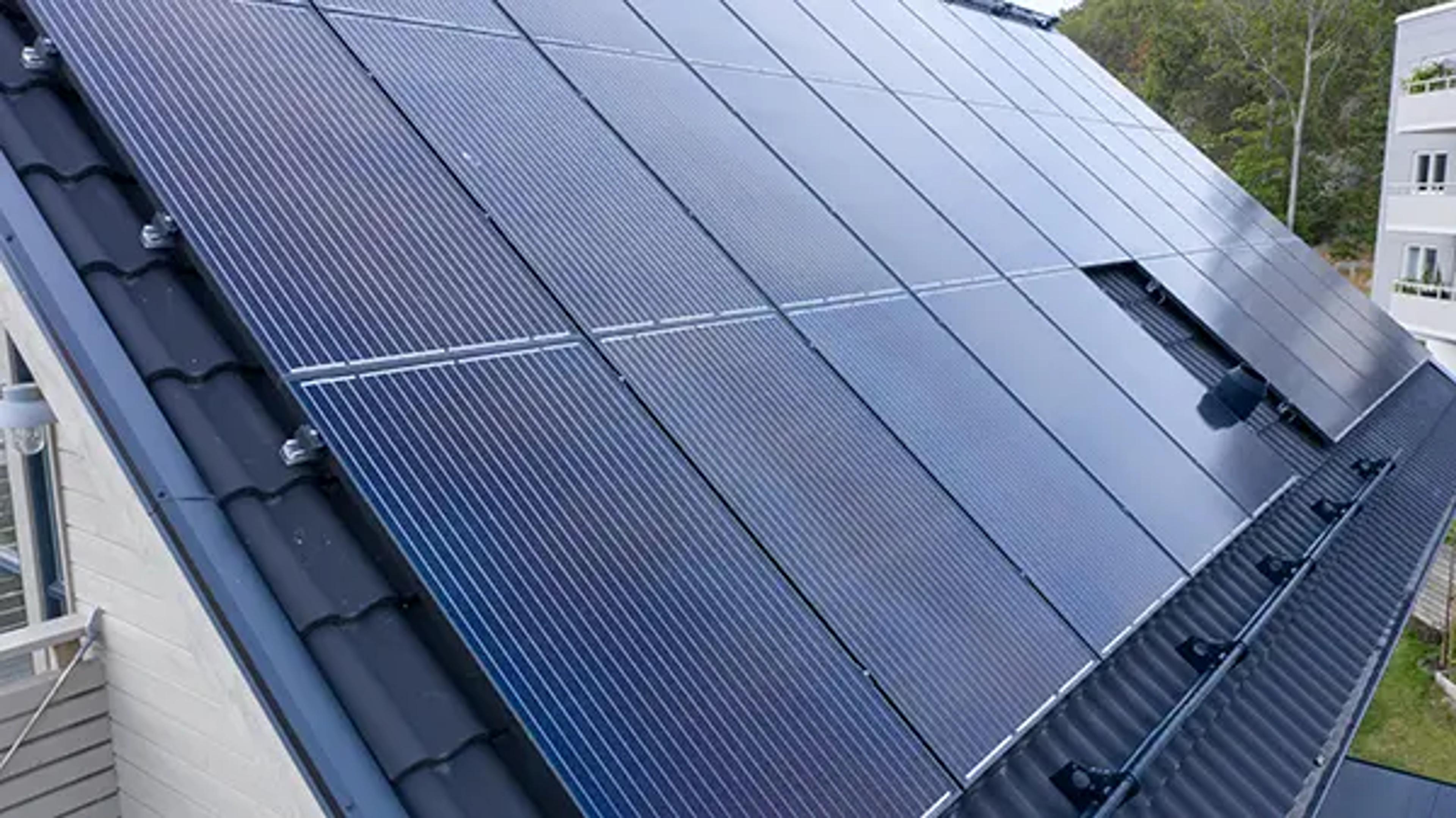 På bilden sysn ett hustak med många solpaneler