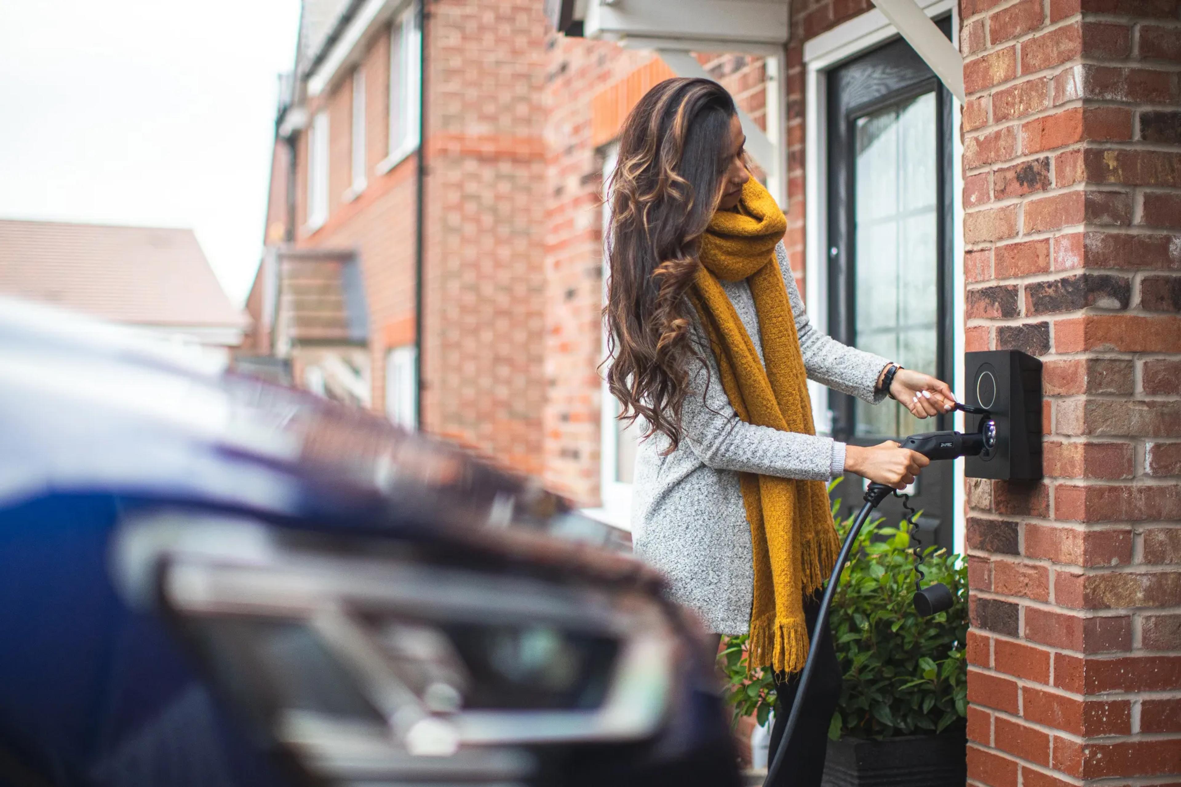 Woman plugging in an EV charger