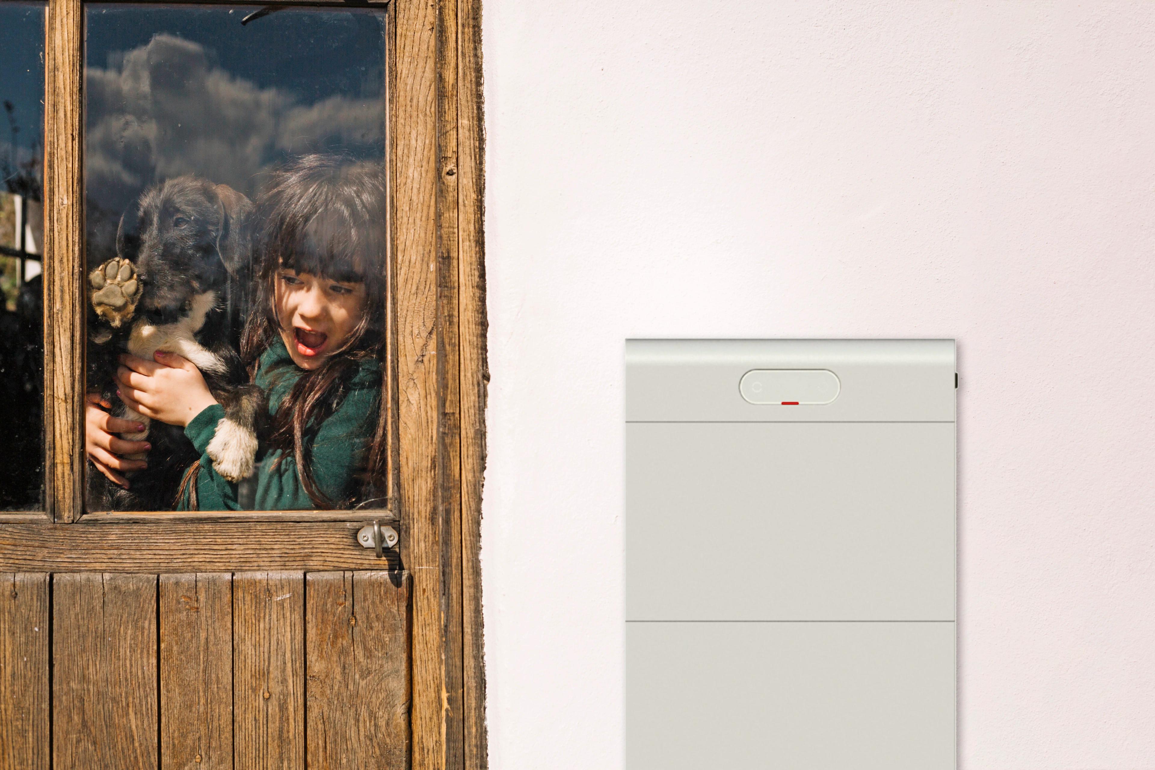 Mädchen mit einem Hund und einem Batteriespeicher