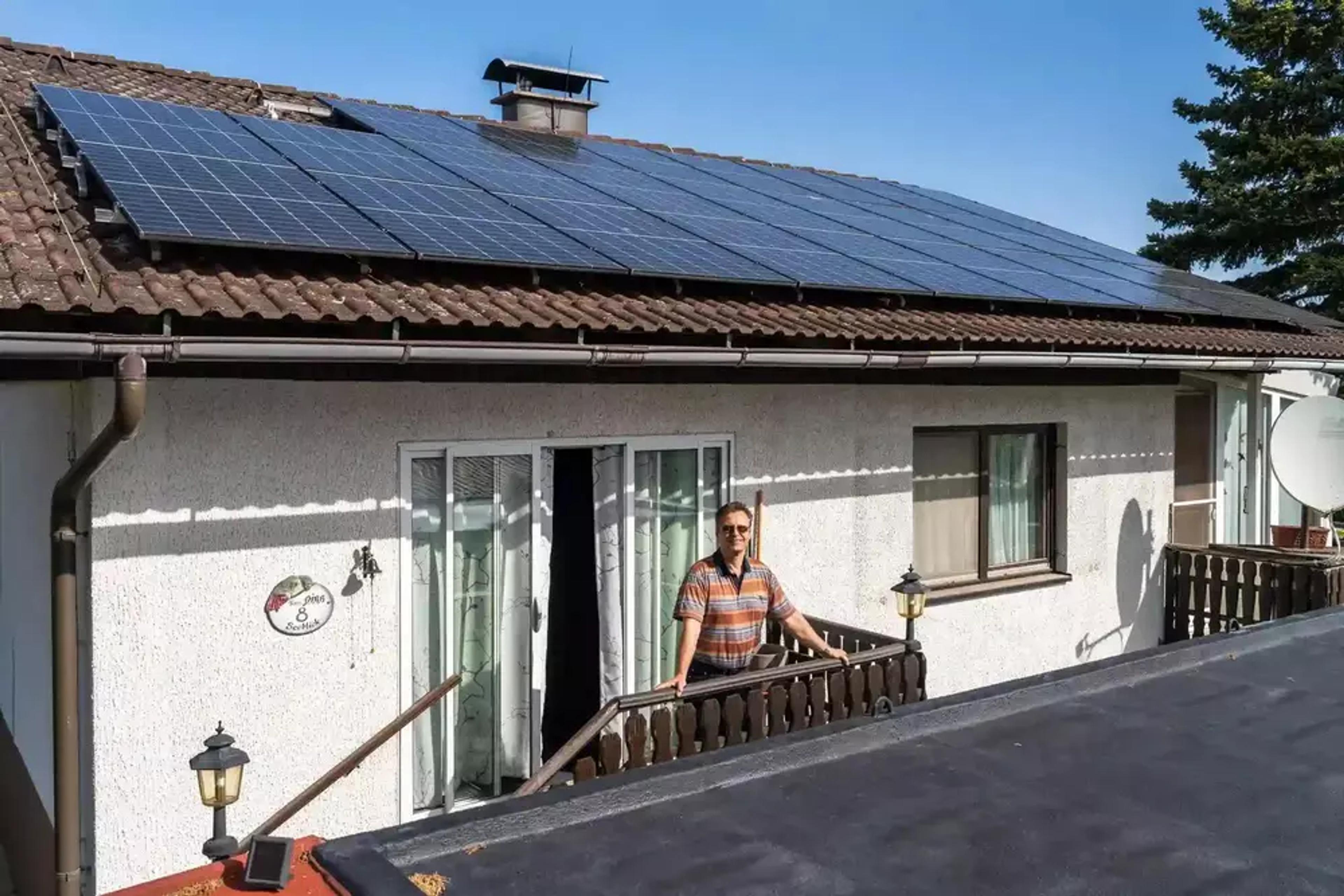 Mann vor Haus mit PV