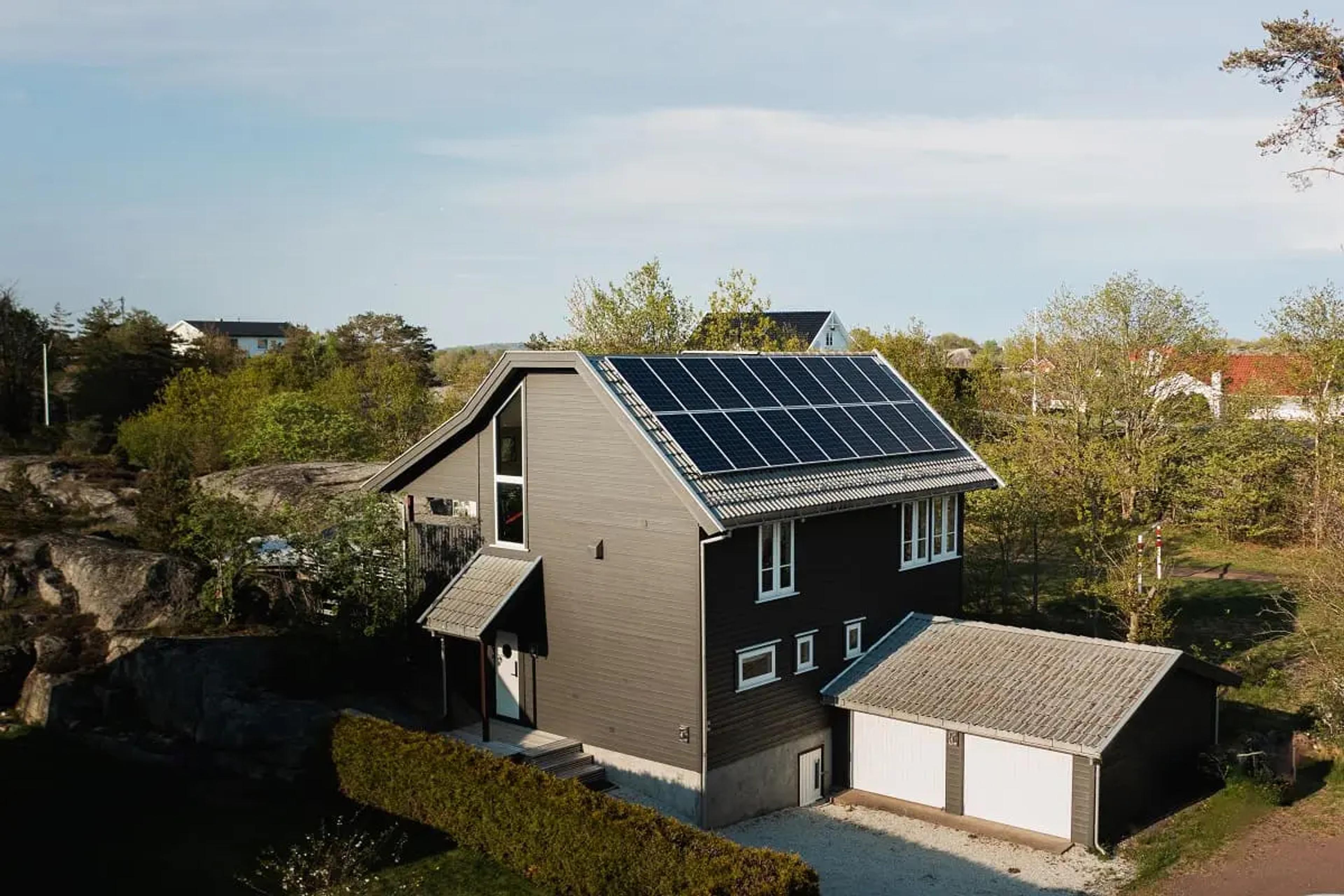 18 st solpaneler på modernt hus i kuperat landskap