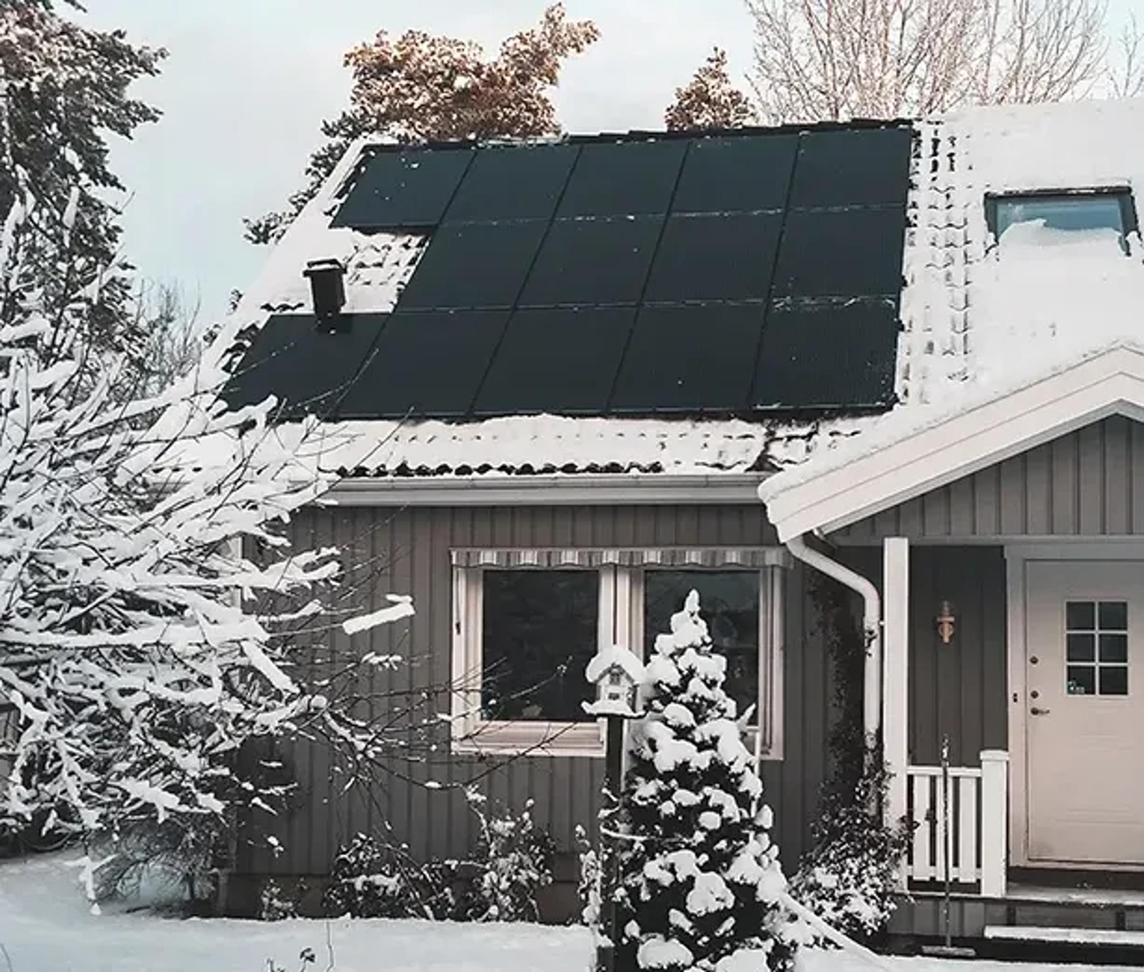 dak met zonnepanelen in de sneeuw