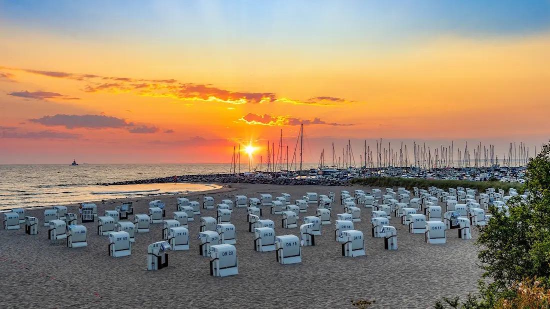 Strandkörbe auf einem Strand im Sonnenuntergang in Mecklenburg-Vorpommern.