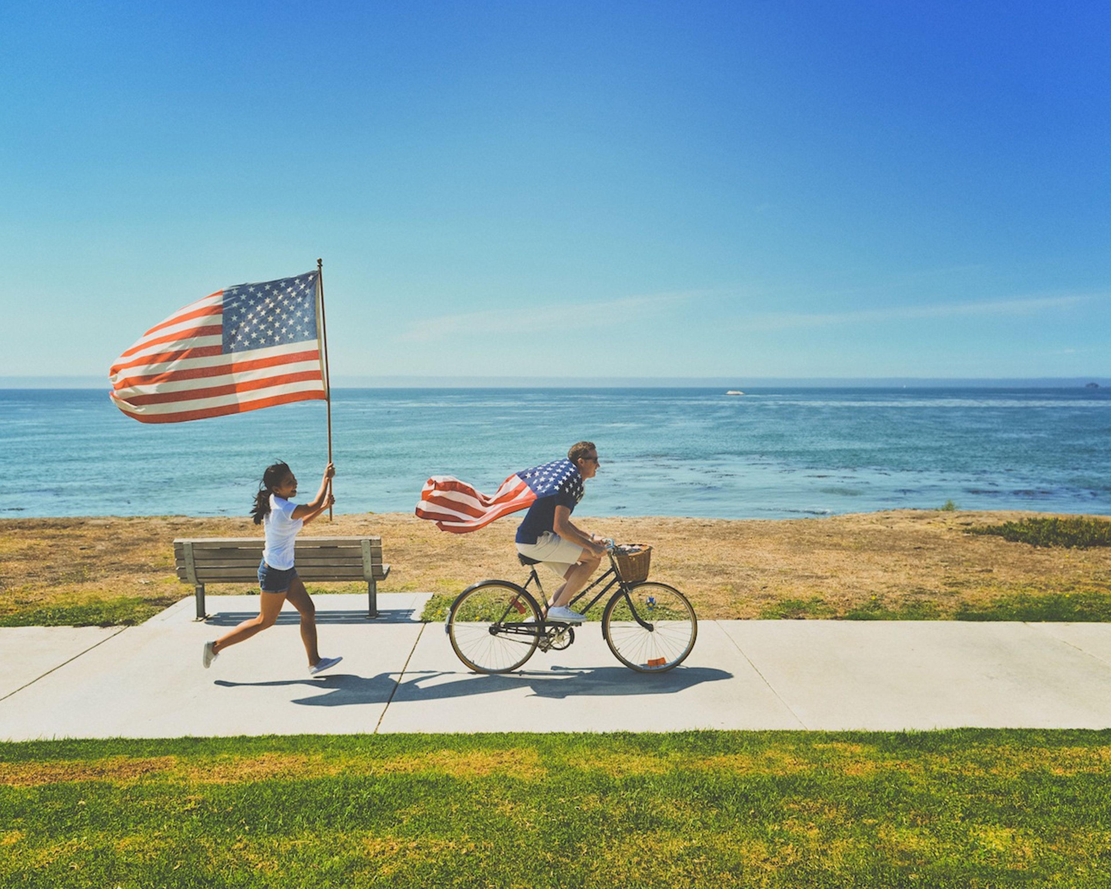 två personer framför strand med amerikanska flaggor
