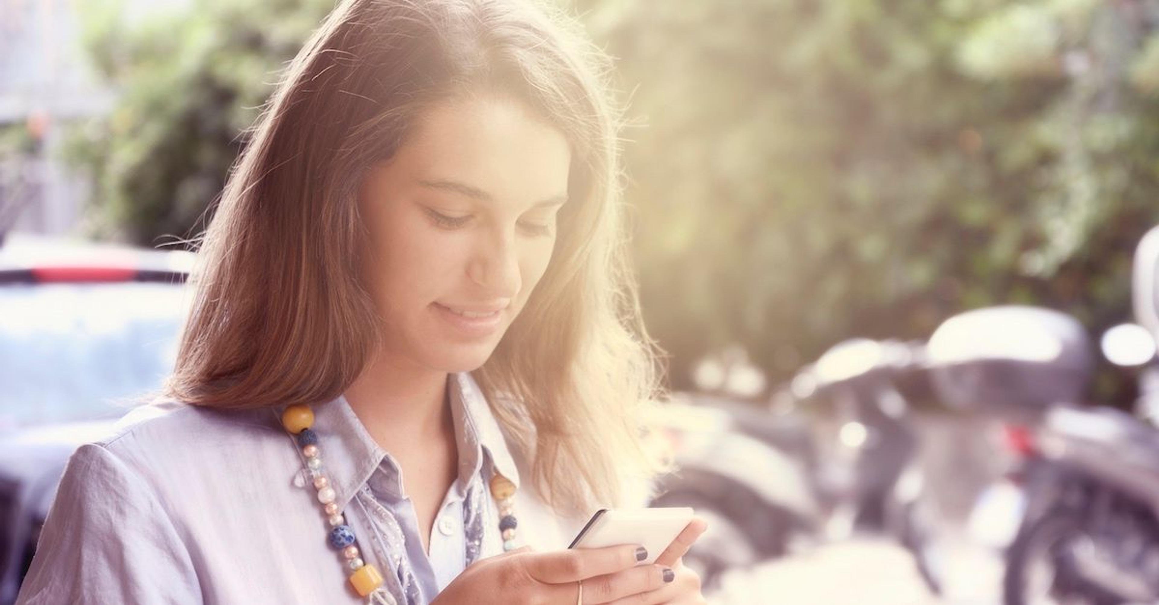 kvinne ser på mobiltelefonen hennes
