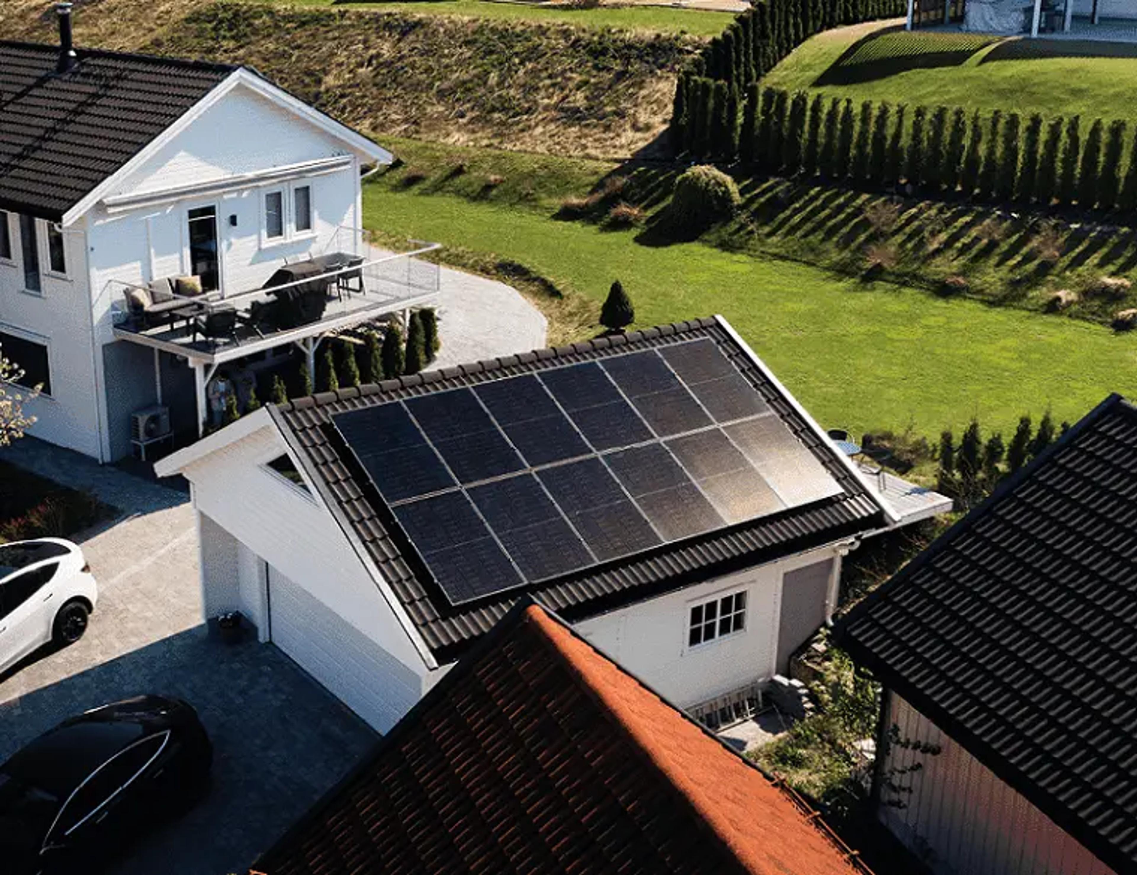 to elbiler og solcellepaneler på garasjen