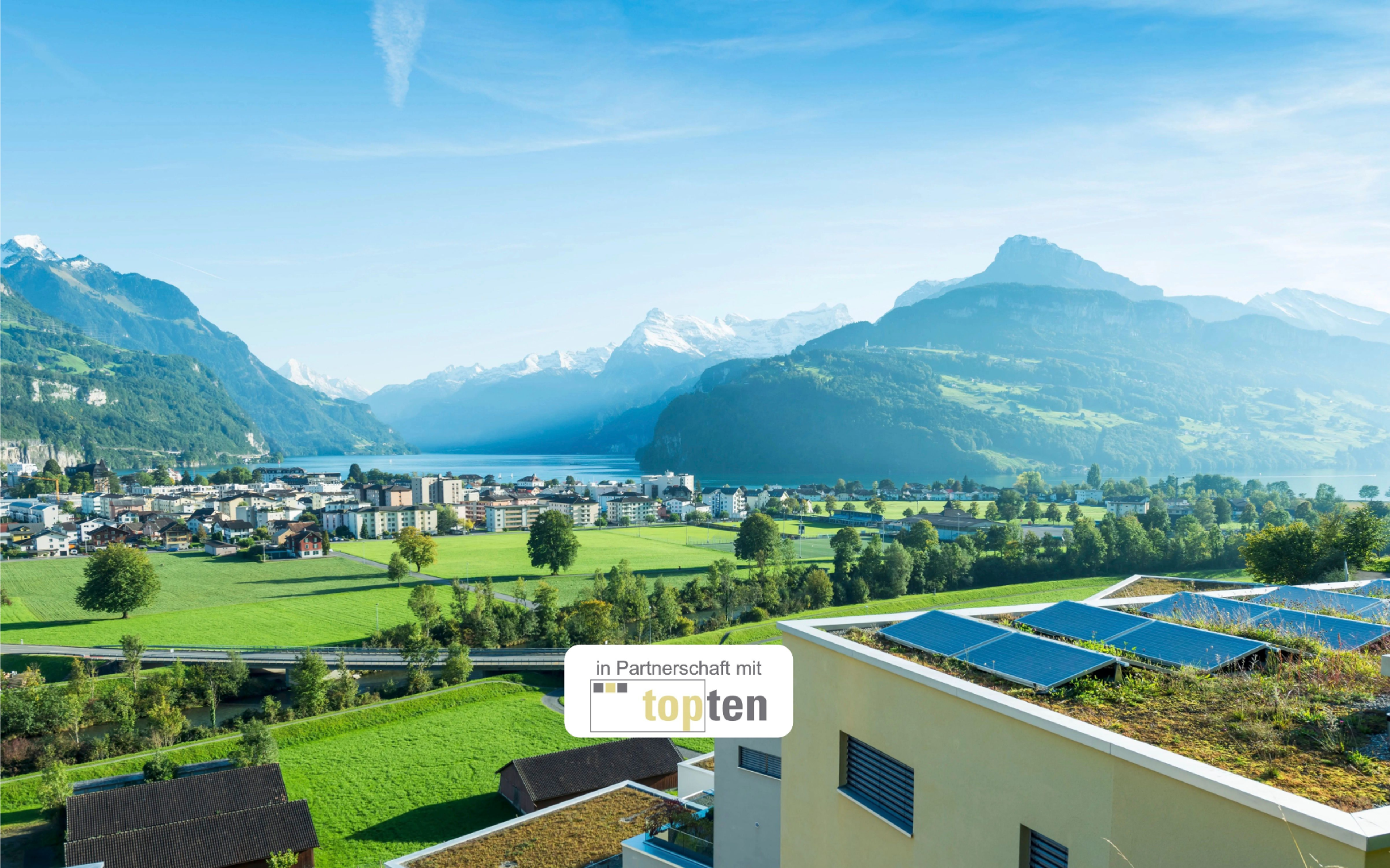 Gebäude mit Photovoltaikanlage mit schweizer Landschaft im Hintergrund