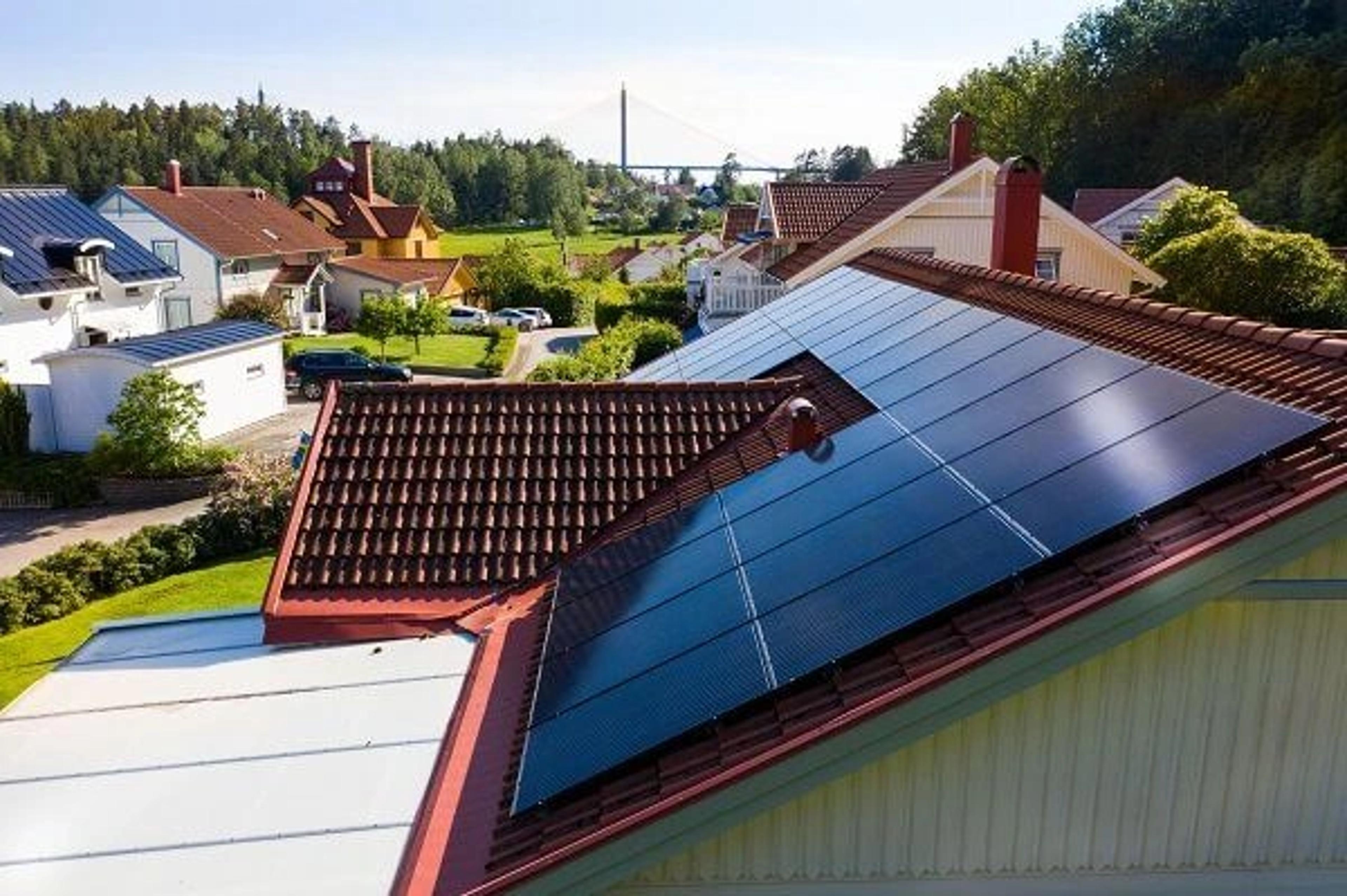 hustak med solceller i forgrunnen og flere hus i bakgrunnen