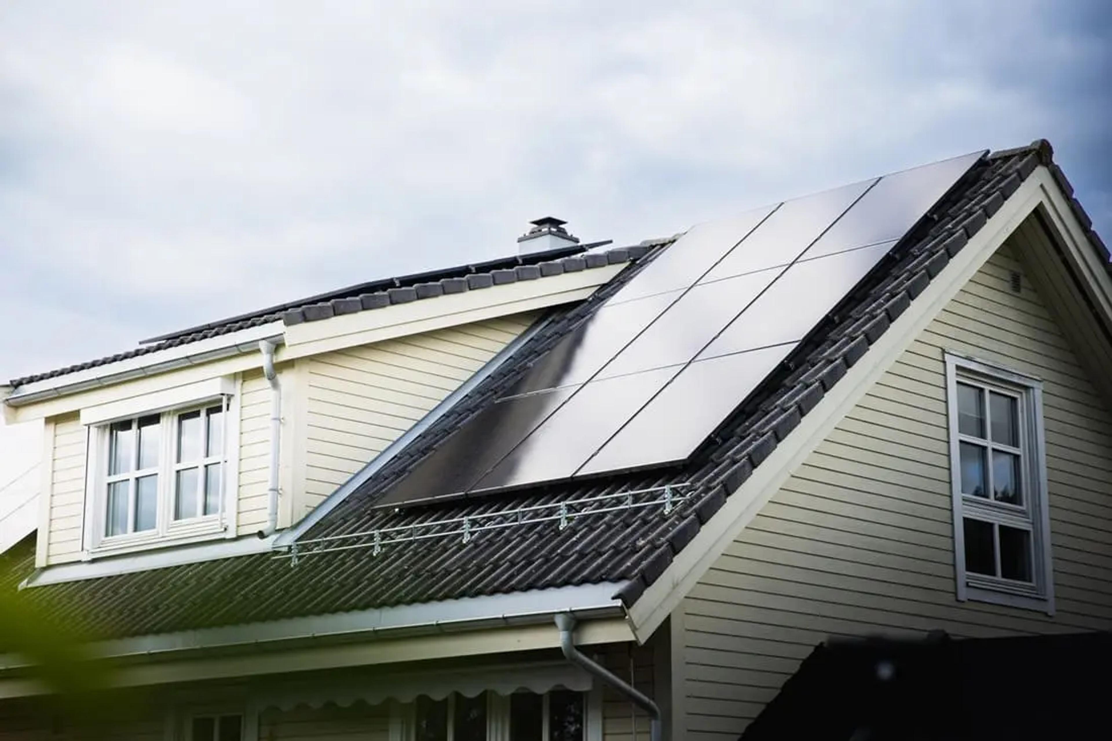 solcellepaneler som produserer strøm på et hustak