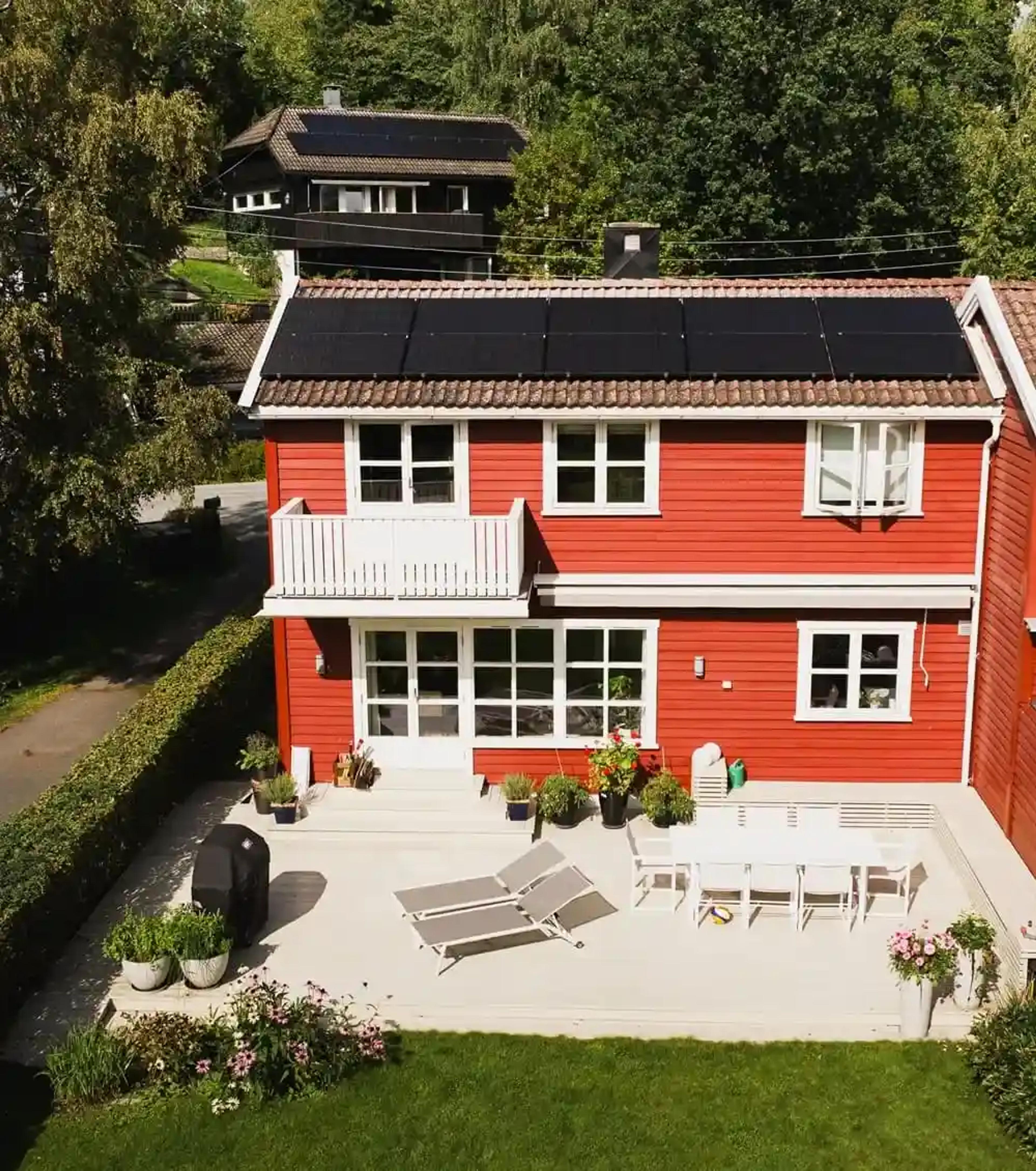 rødt hus med solceller på taket