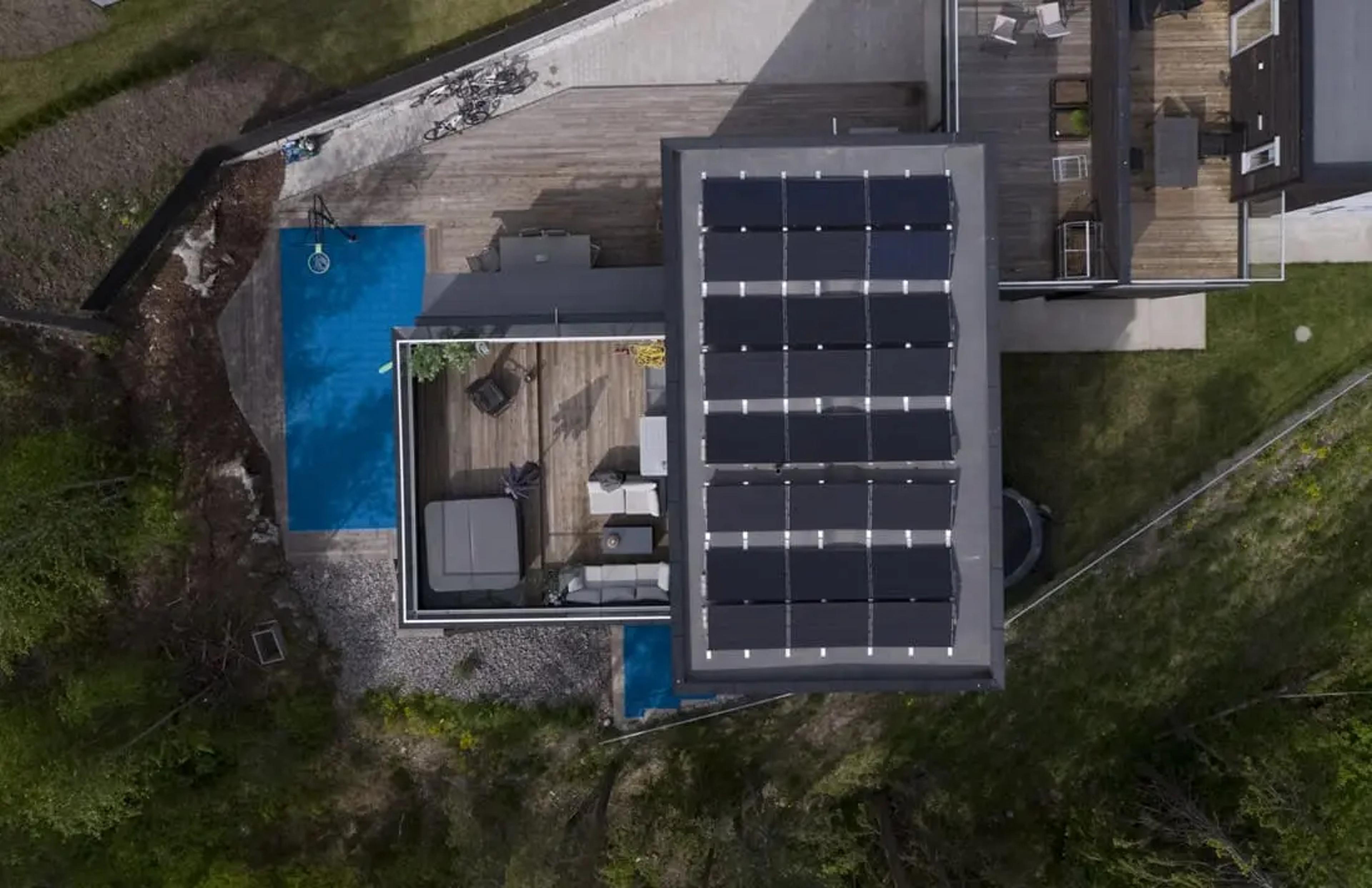 fågelvy över villa med solpaneler på platt tak