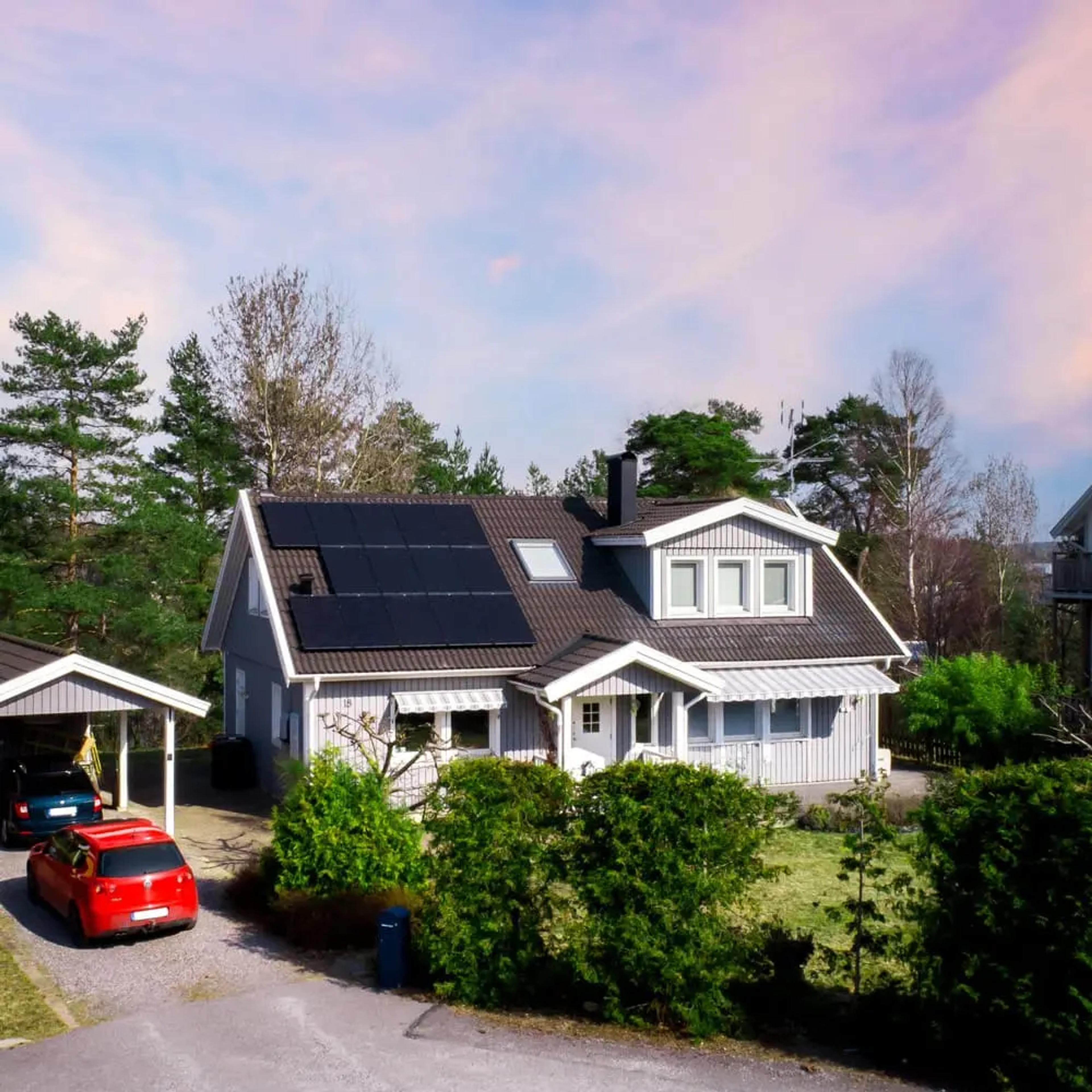 hus med stora solpaneler som lutar