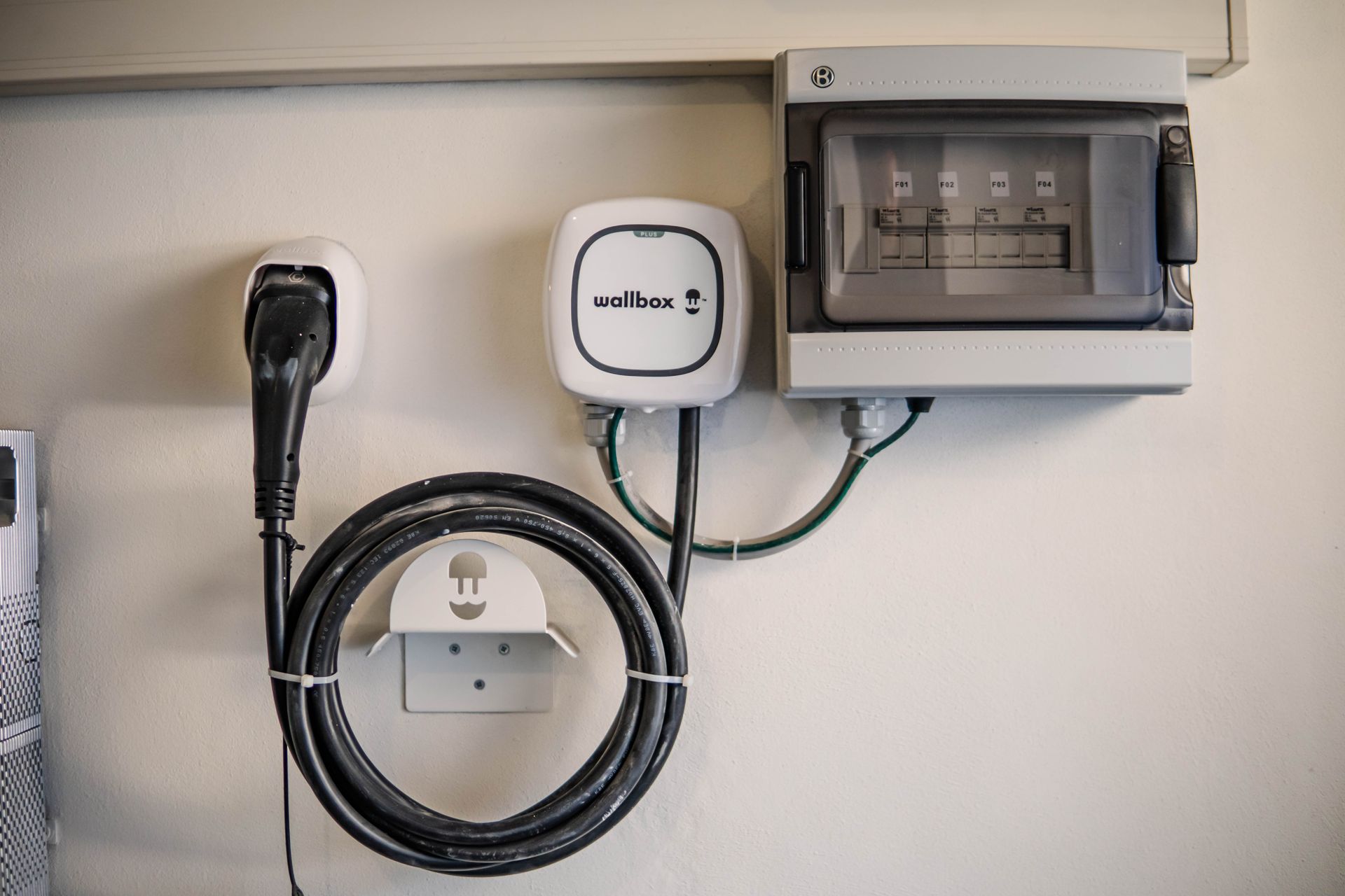 Eine Wallbox zum Laden eines Elektroautos an der Wand einer Garage.