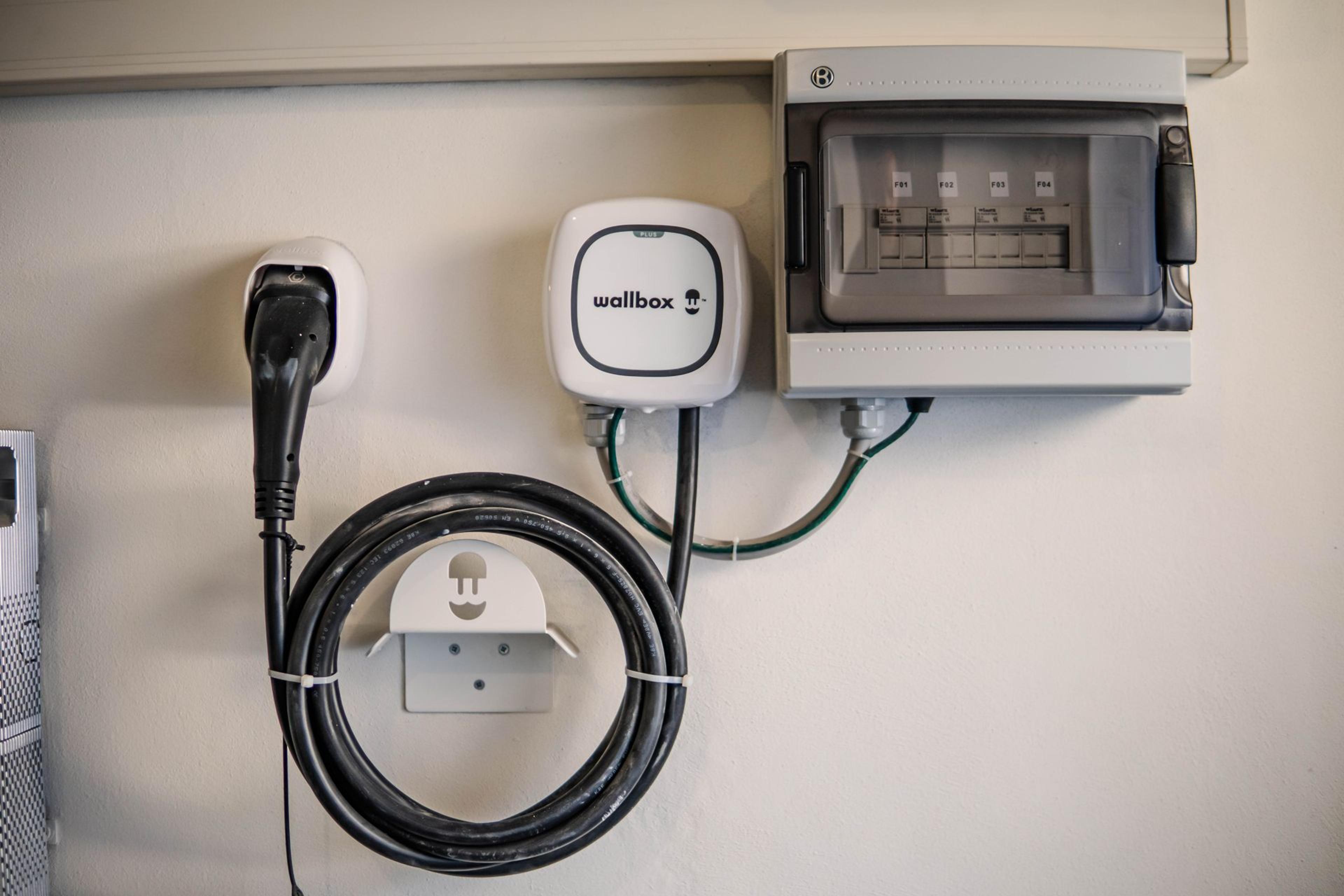 Eine Wallbox zum Laden eines Elektroautos an der Wand einer Garage.