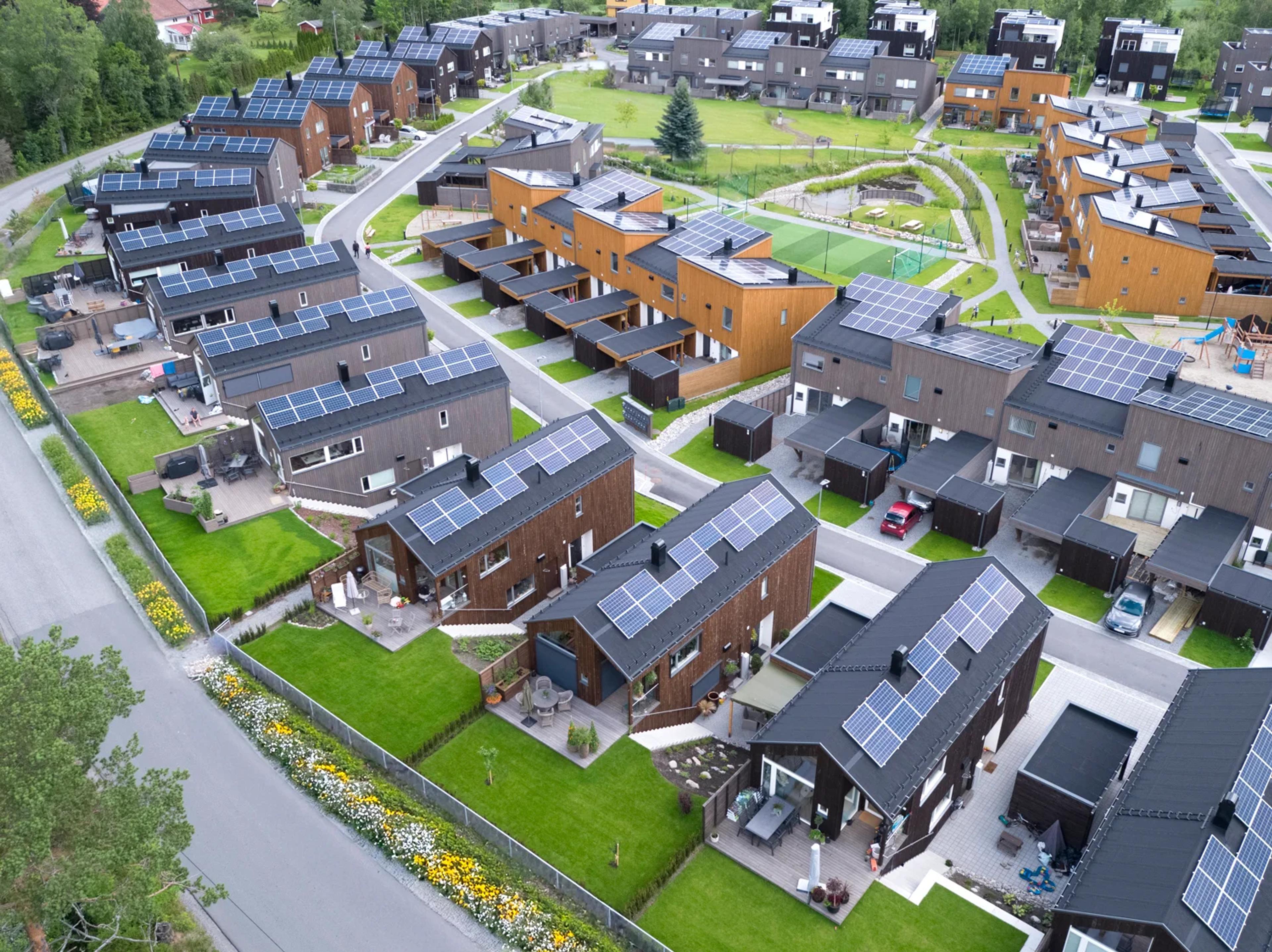En gruppe hus med solcellepaneler på takene