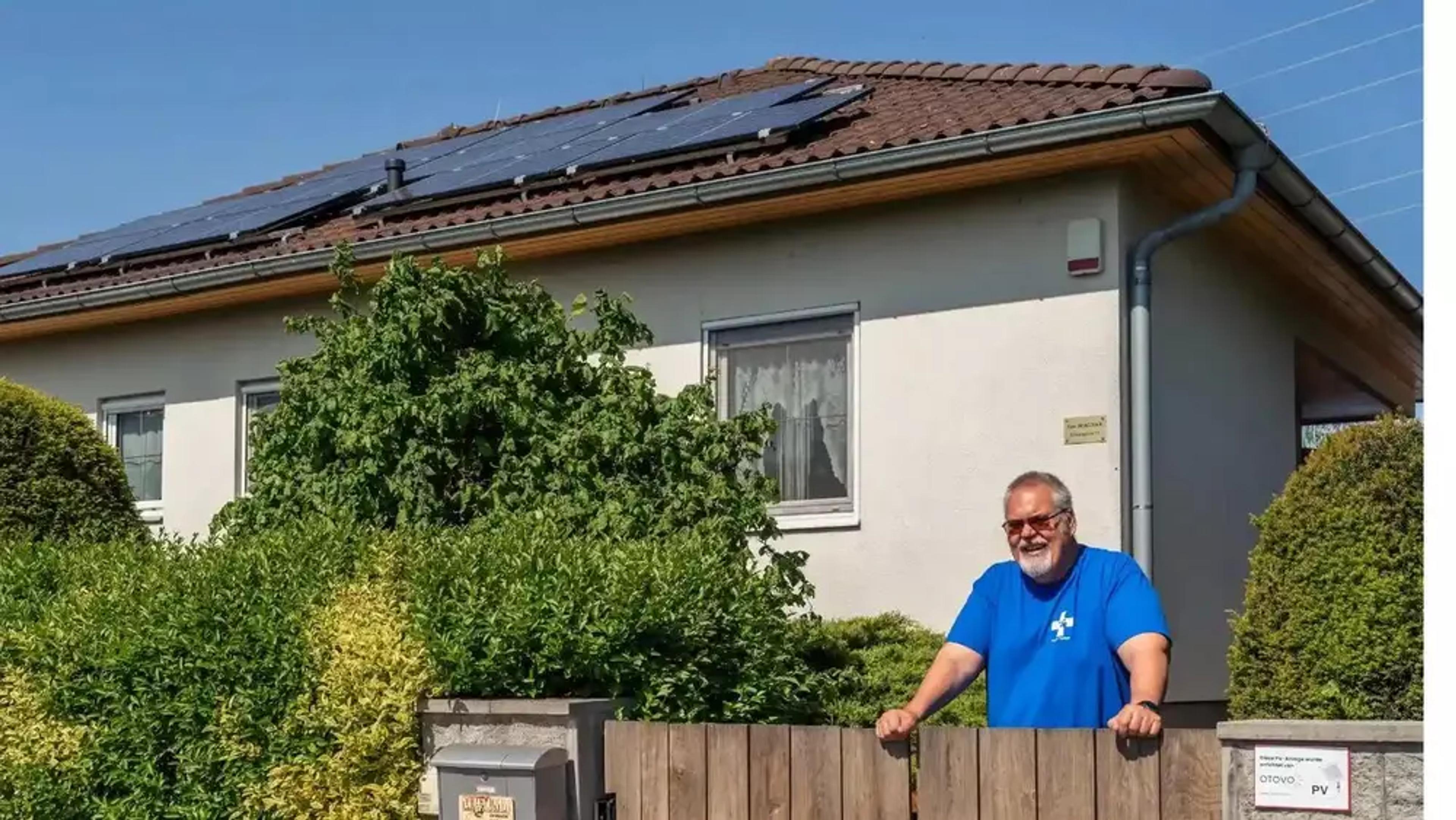 Mann vor Haus mit PV