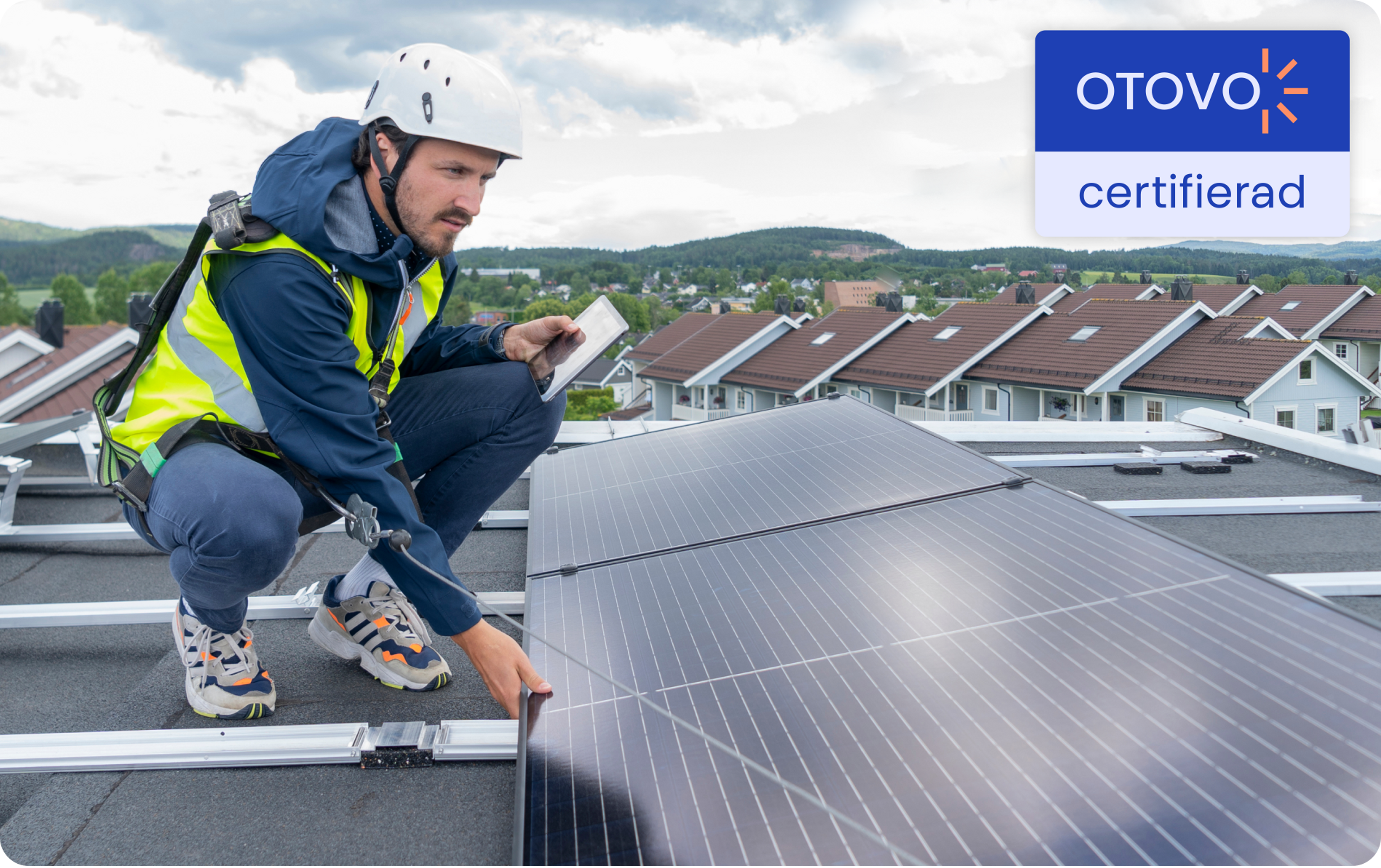 en otovo-certifierad installatör som undersöker solpanelerna på ett platt tak