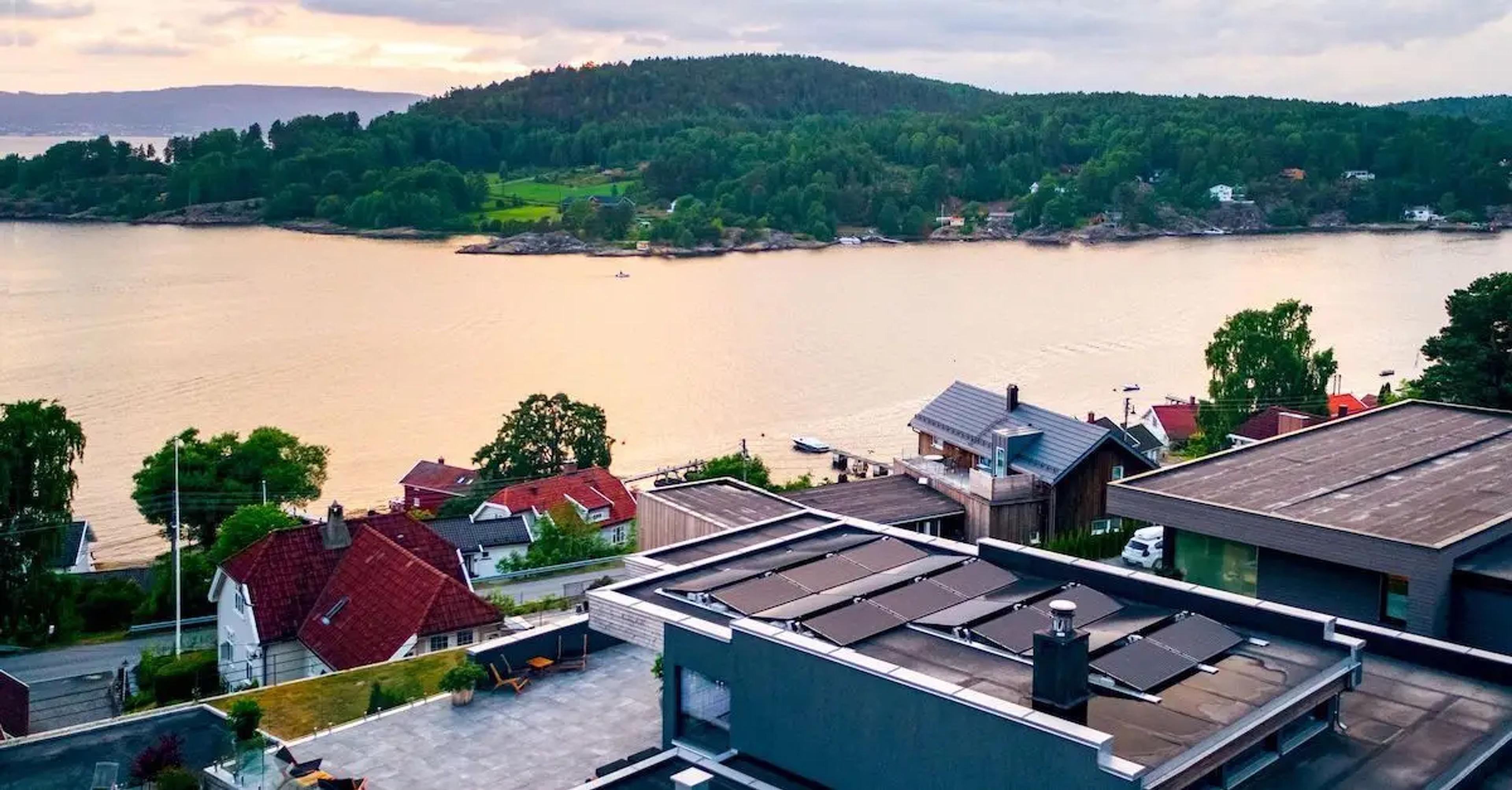 Solpaneler på platt tak framför vatten