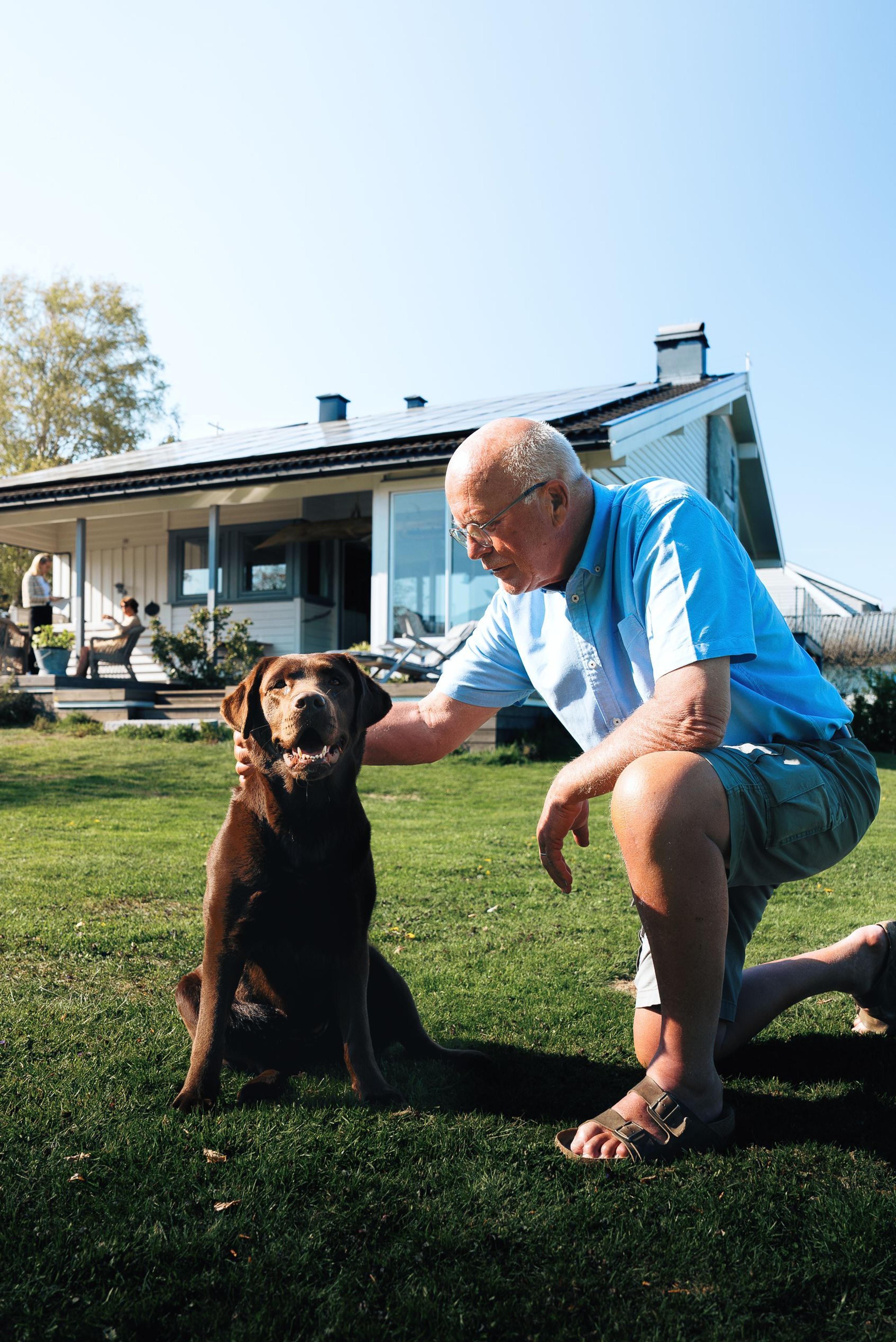 Man with dog in front of solar powered house
