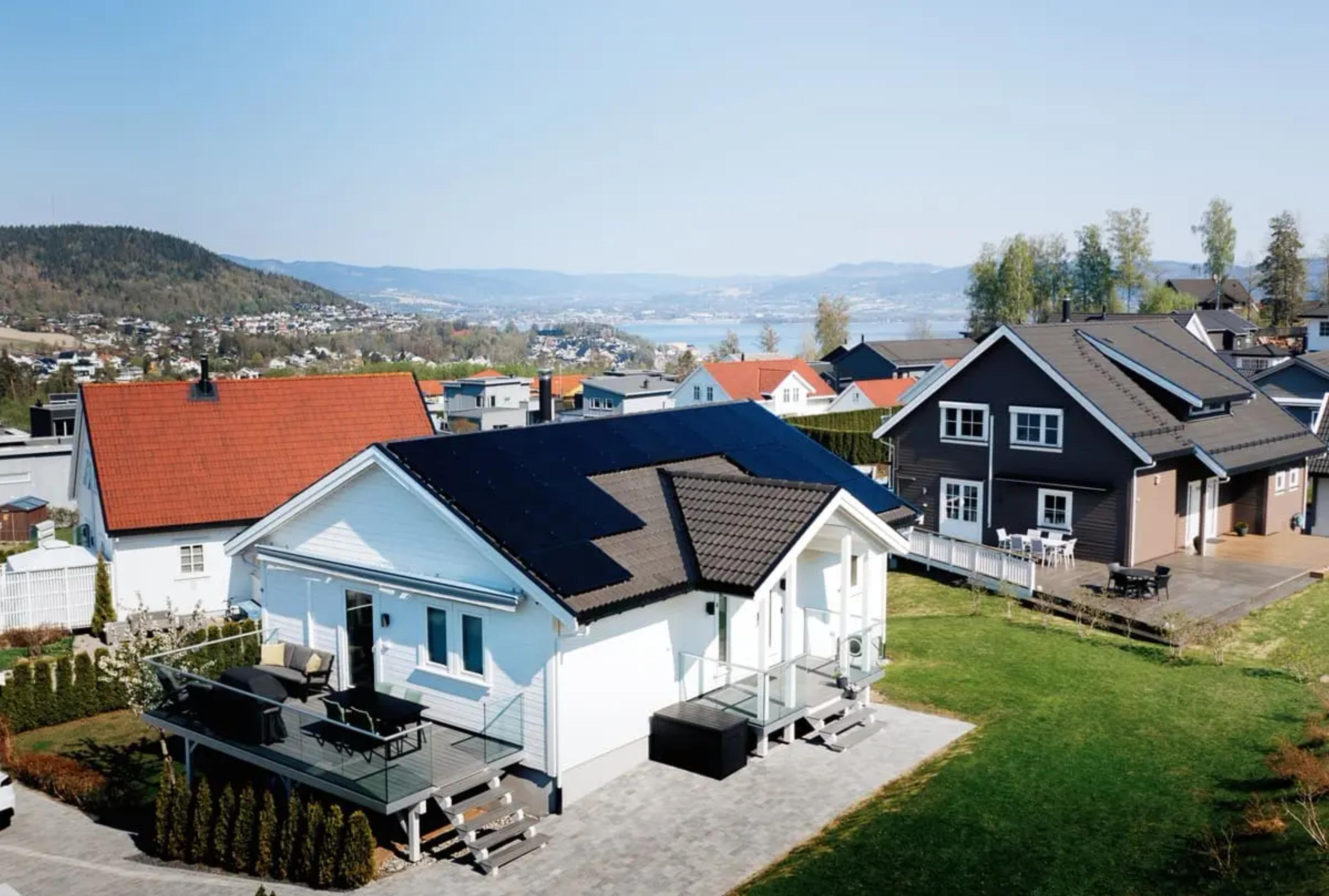 hvitt hus i nabolaget med solceller på taket