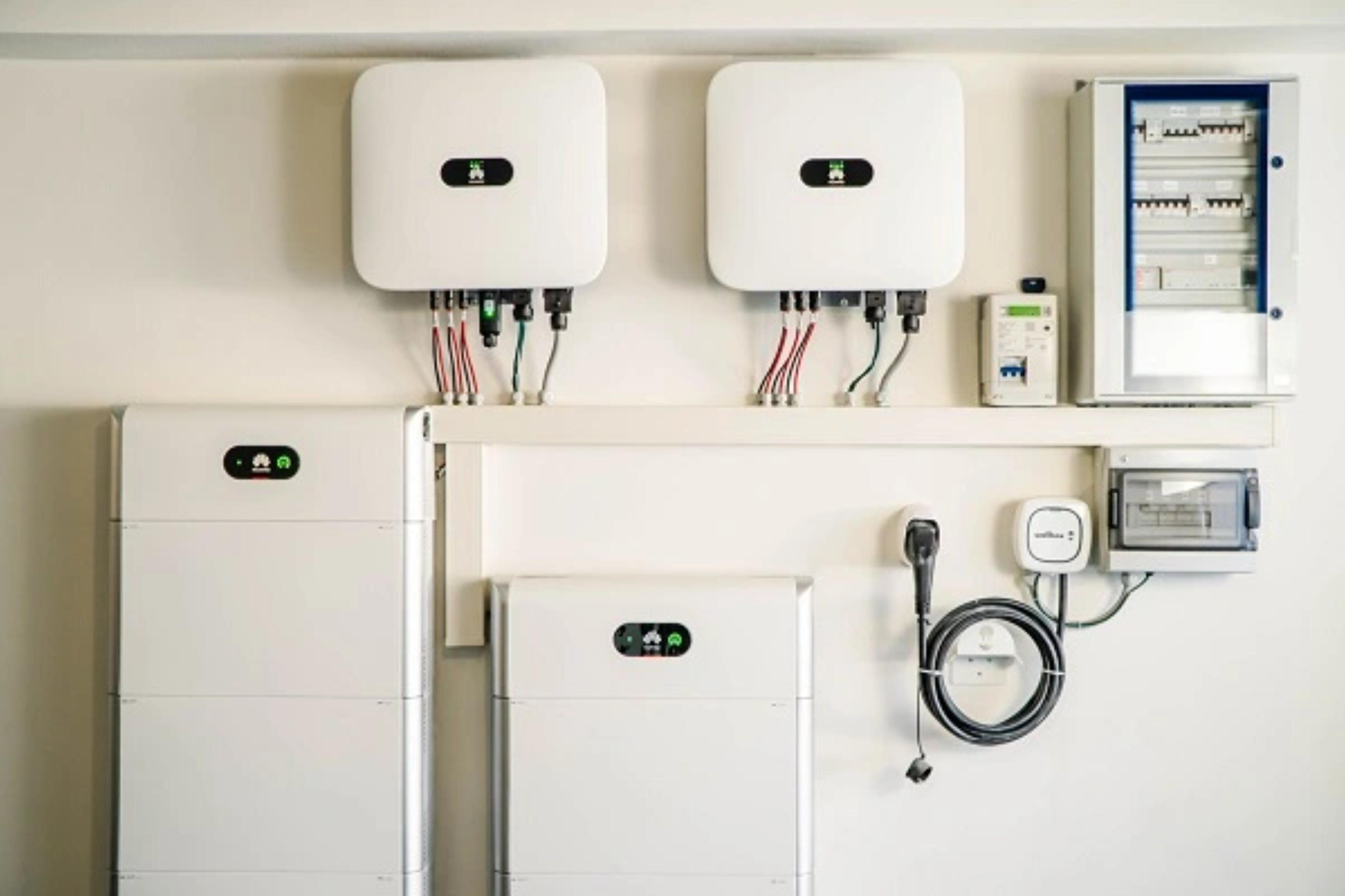 två solcellsbatterier och växelriktare på en vägg