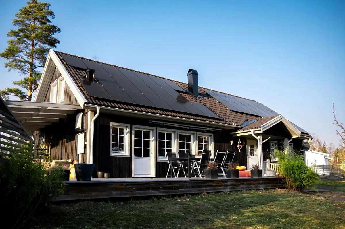 svart hus med solceller på sadeltak