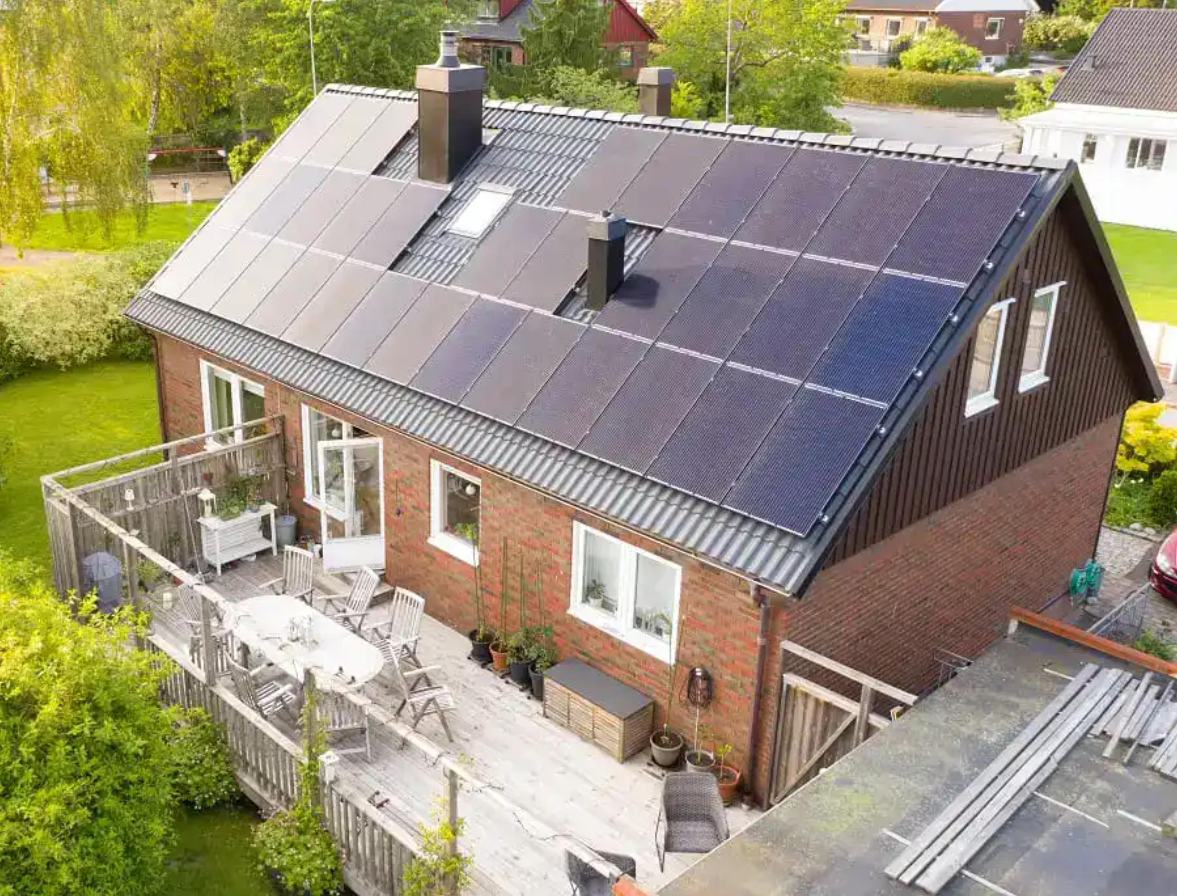 tegelhus med svarta solceller på taket