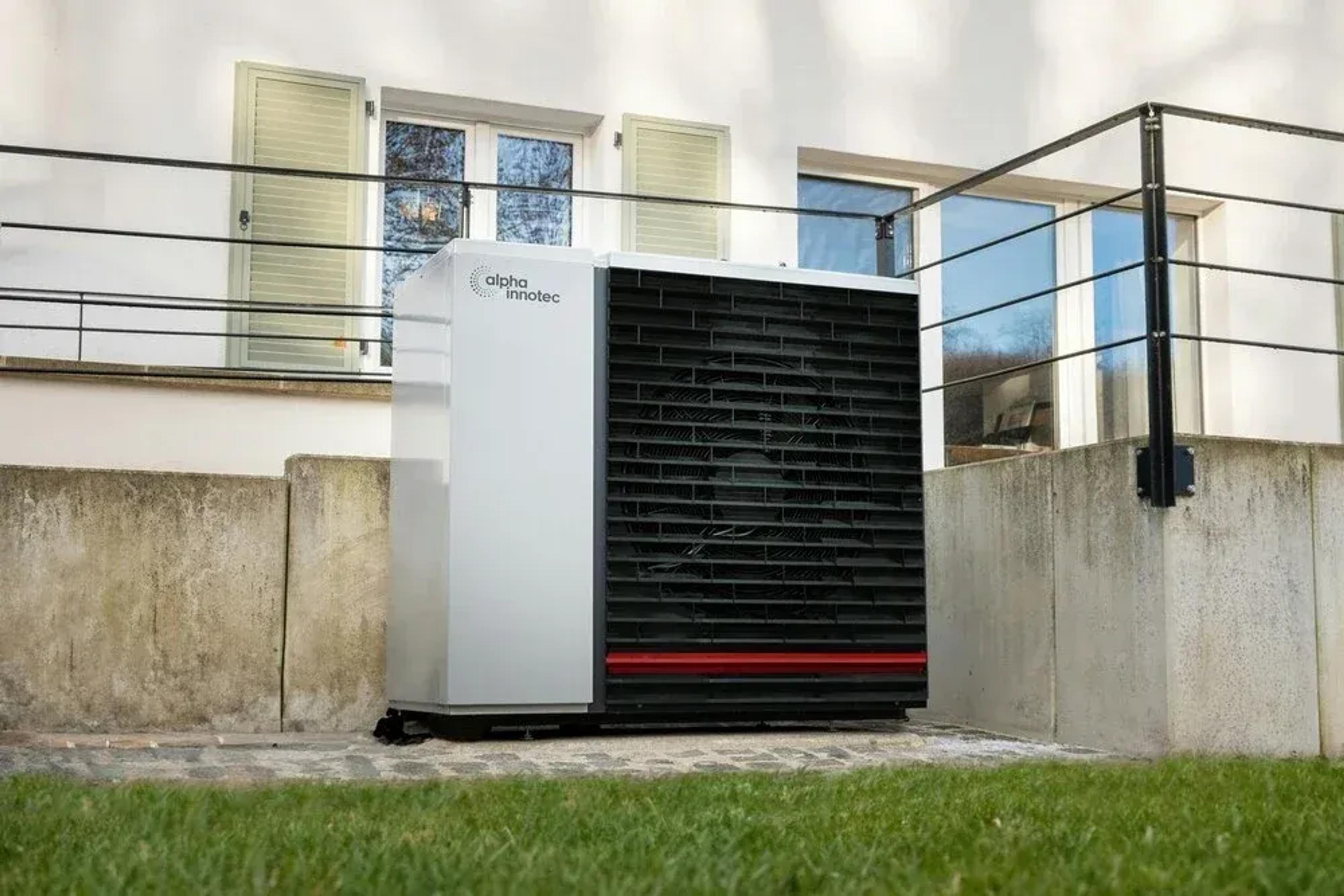 Wärmepumpe vor der Terrasse eines Hauses